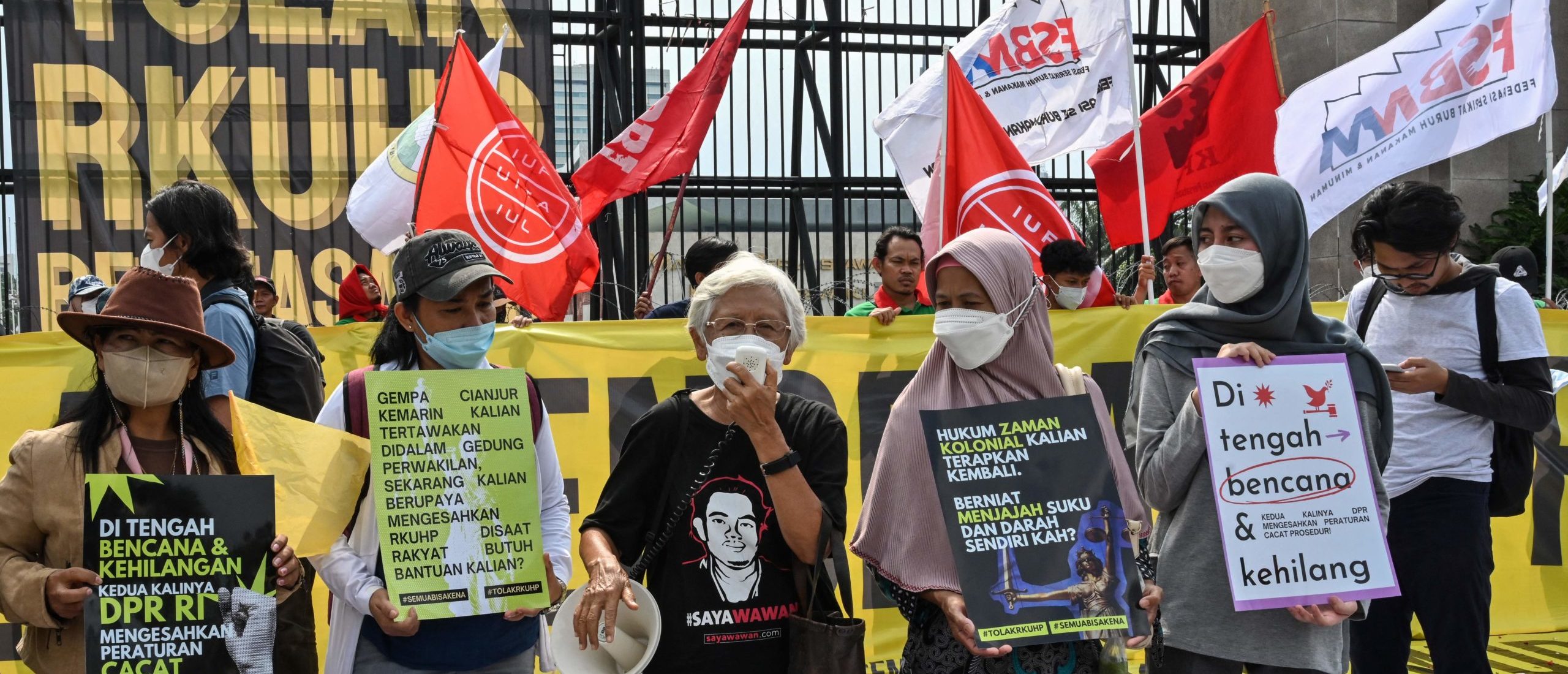 This picture taken on December 5, 2022 shows activists holding a protest against the new criminal code outside the parliament building in Jakarta. - Indonesia's parliament approved on December 6 legislation that would outlaw pre-marital sex while making other sweeping changes to the criminal code -- a move critics deemed as a setback to the country's freedoms. (Photo by ADEK BERRY / AFP) (Photo by ADEK BERRY/AFP via Getty Images)