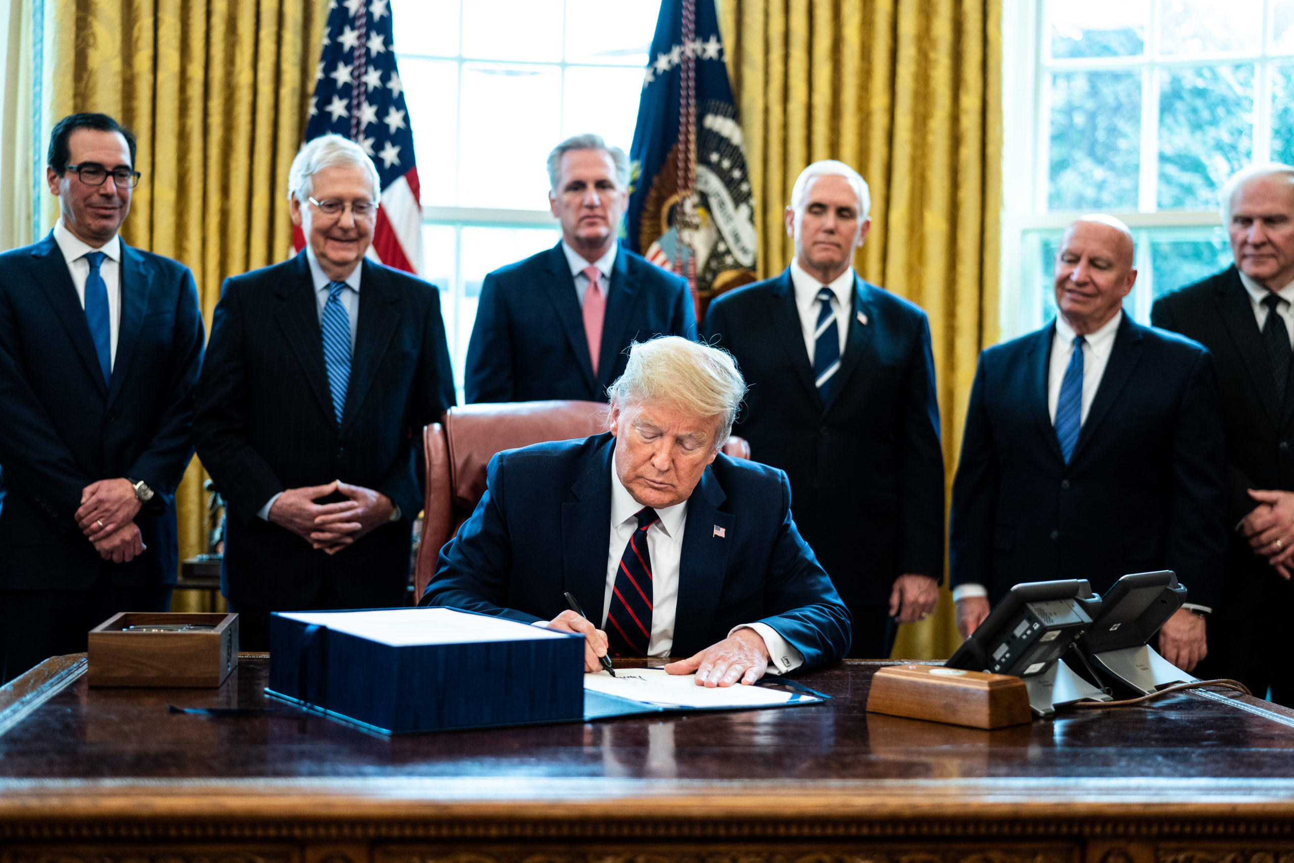 WASHINGTON, DC - MARCH 27: U.S. President Donald Trump signs H.R. 748, the CARES Act in the Oval Office of the White House on March 27, 2020 in Washington, DC. (Photo by Erin Schaff-Pool/Getty Images)