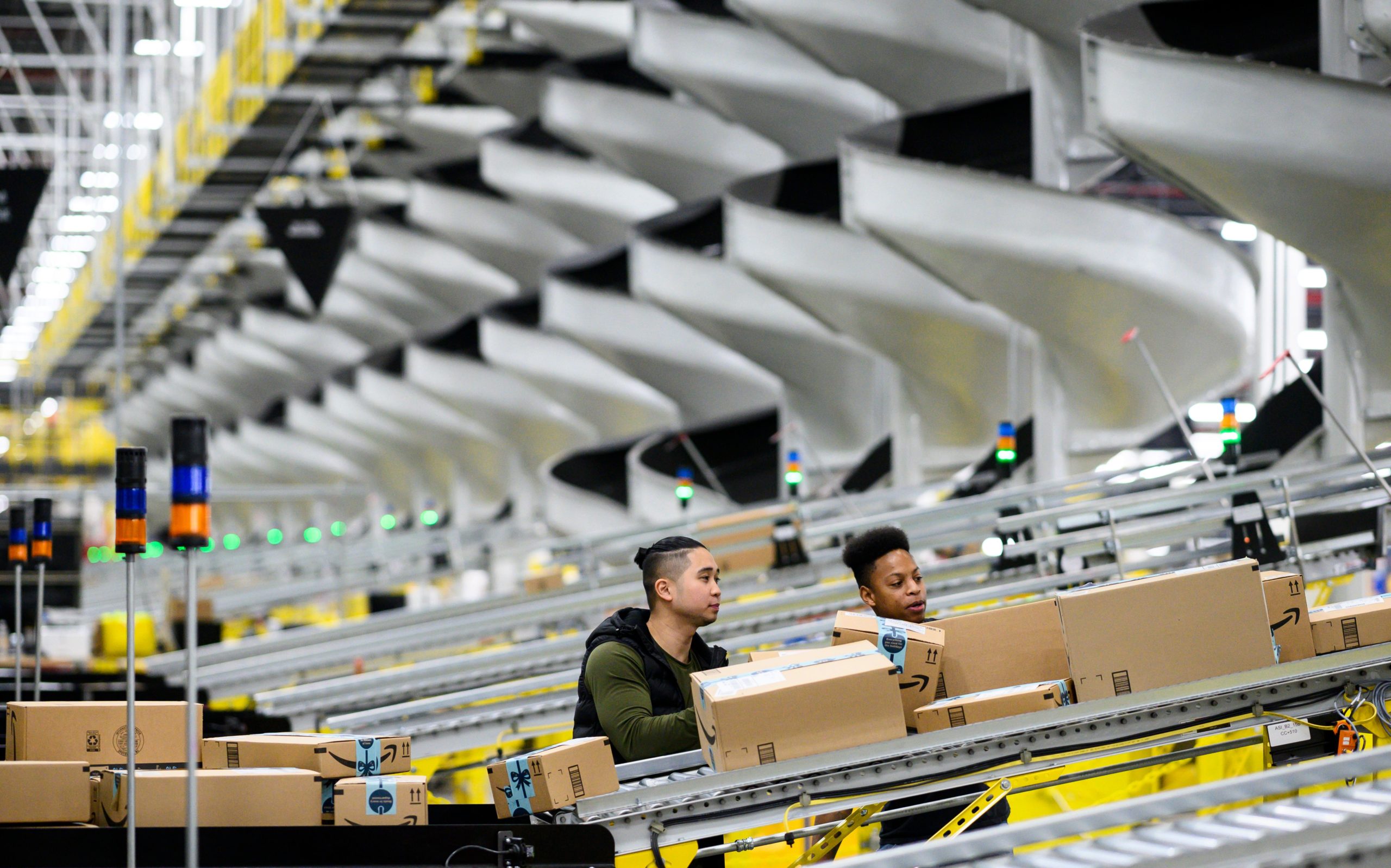 Men work at a distribution station in the 855,000-square-foot Amazon fulfillment center in Staten Island, one of the five boroughs of New York City, on February 5, 2019.(JOHANNES EISELE/AFP via Getty Images)