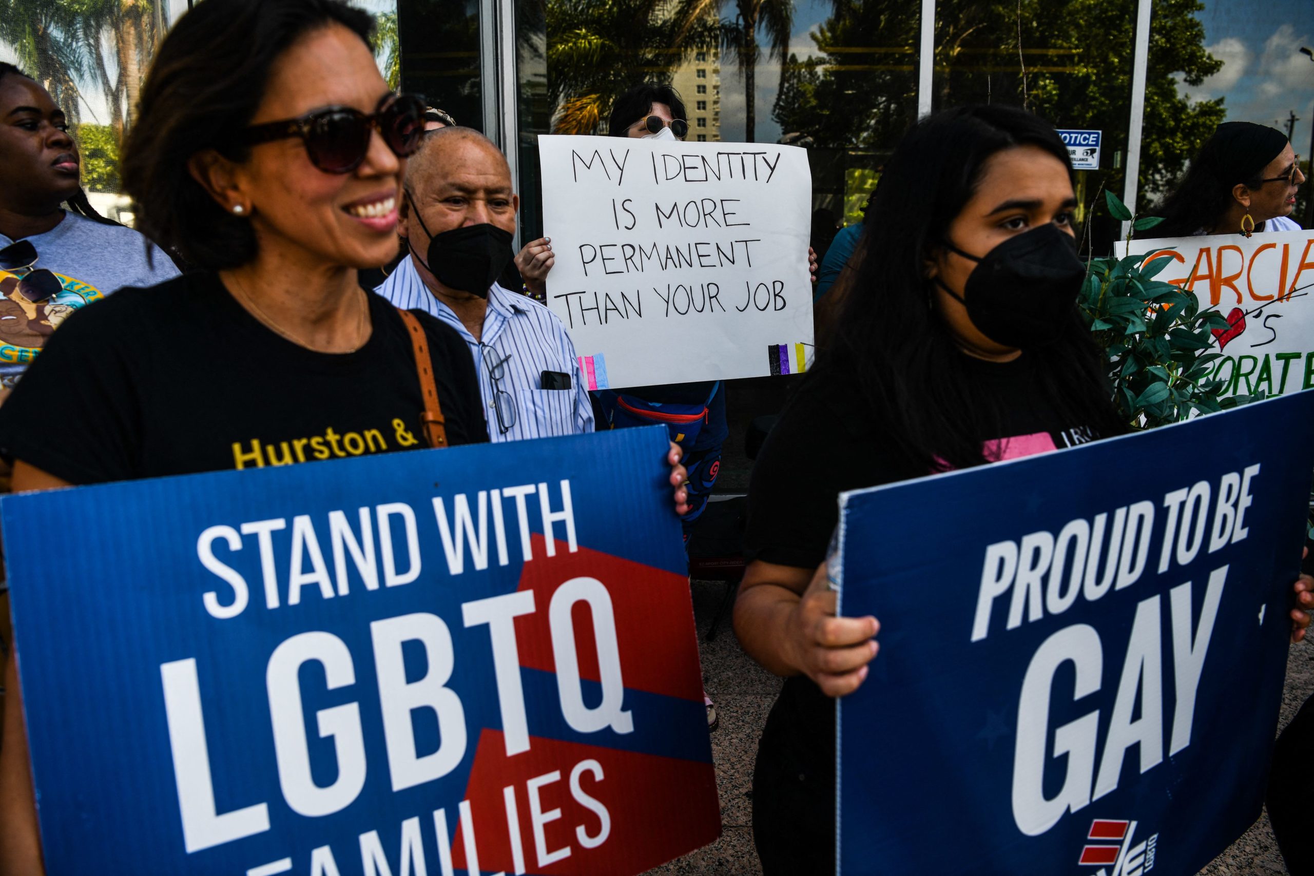 People hold placards as they protest outside the office of Florida State Senator Ileana Garcia in Coral Gables, Florida, on March 9, 2022. - Both the Florida Senate and House passed a bill that would limit what classrooms can teach about sexual orientation and gender identity. (Photo by CHANDAN KHANNA / AFP) (Photo by CHANDAN KHANNA/AFP via Getty Images)