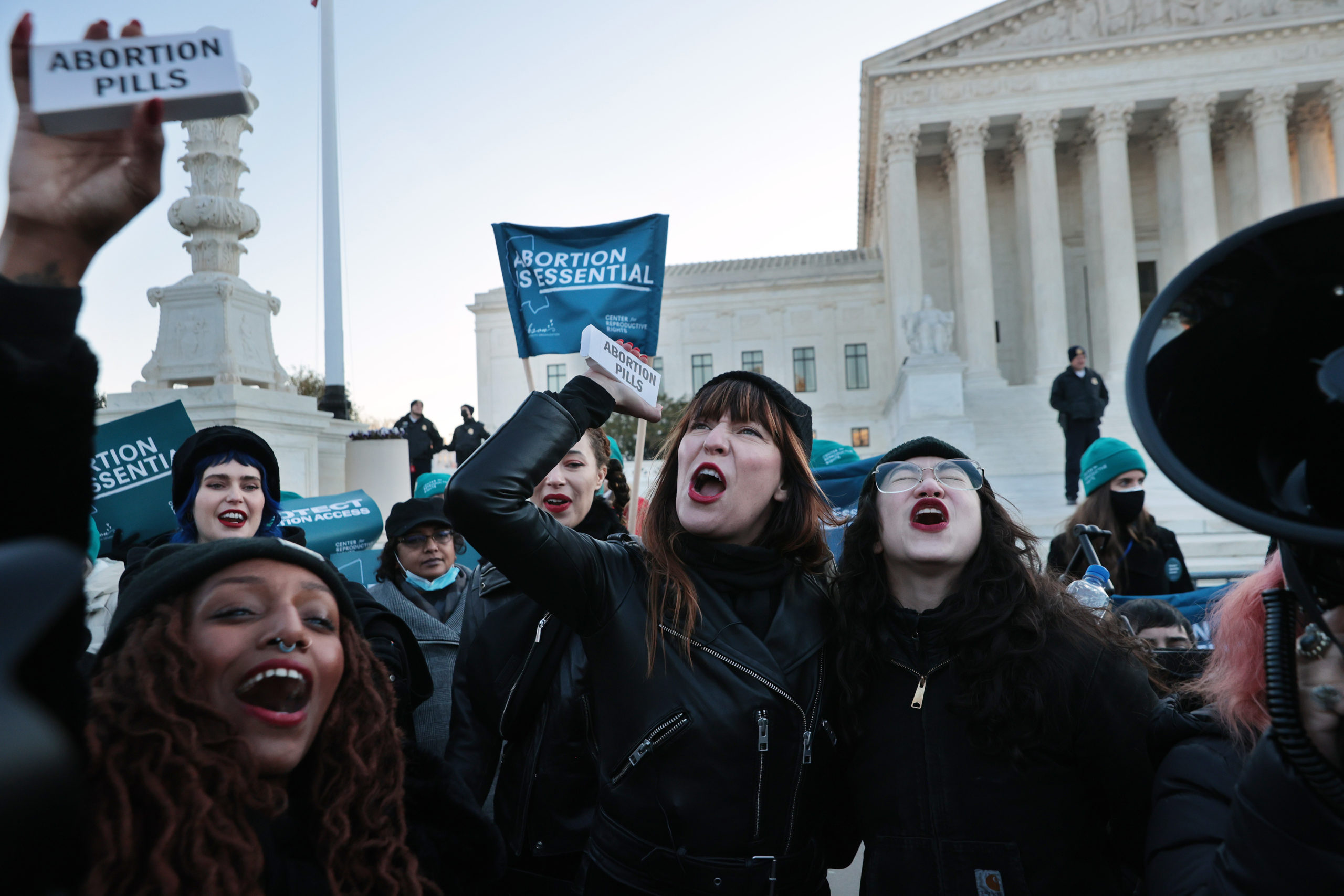 Alana Edmondson, Lila Bonow, Amelia Bonow, Aiyana Knauer celebrate after takiong abortion pills while demonstrating in front of the U.S. Supreme Court as the justices hear hear arguments in Dobbs v. Jackson Women's Health, a case about a Mississippi law that bans most abortions after 15 weeks, on December 01, 2021 in Washington, DC.