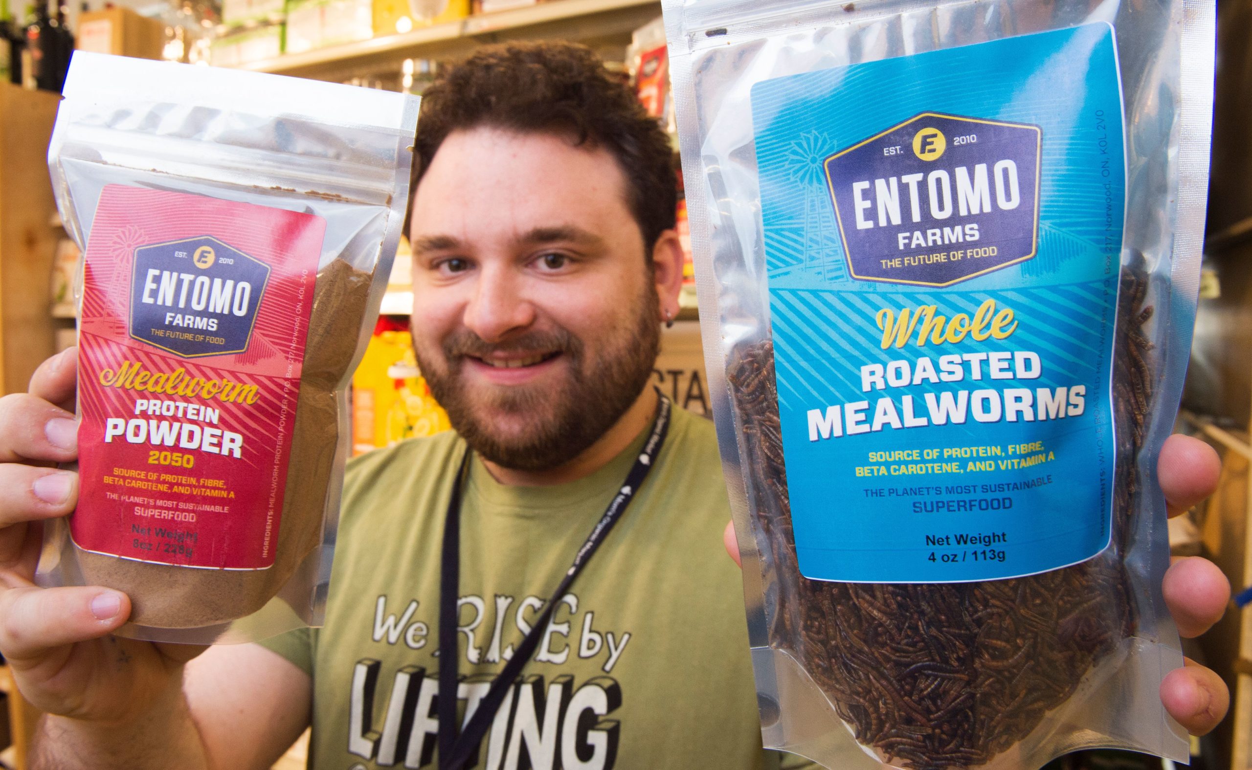 Kyle Morgan, Grocery Manager at MOM's Organic Market in Washington, DC, holds bags of Mealworm Protein Powder and Whole Mealworms on April 12, 2017. (Photo by PAUL J. RICHARDS/AFP via Getty Images)