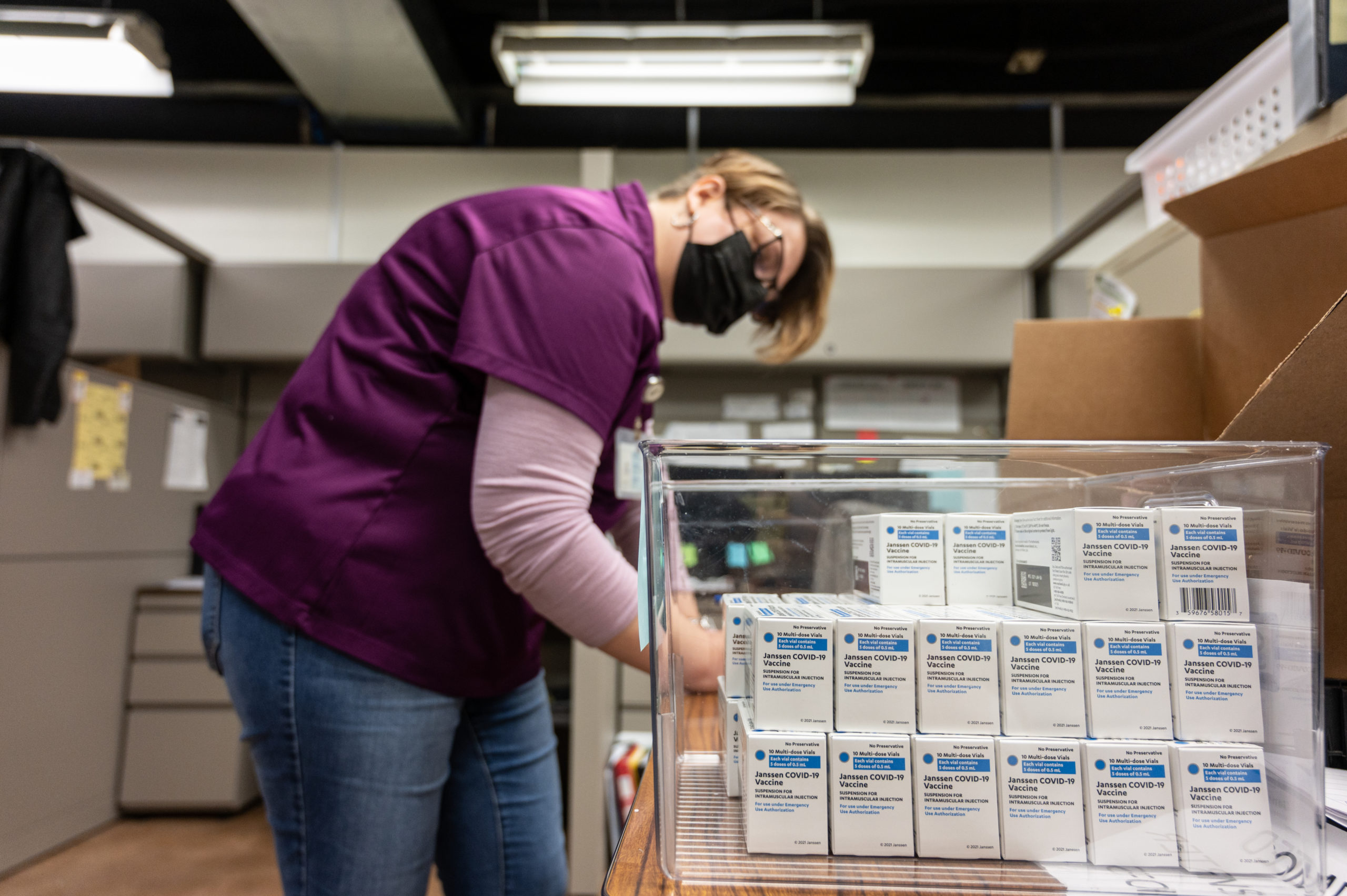 LOUISVILLE, KY - MARCH 04: Janet Gerber, a health department employee, fills out forms as boxes containing Janssen COVID-19 vials sit stacked upon each other shortly after their delivery to Louisville Metro Health and Wellness headquarters on March 4, 2021 in Louisville, Kentucky. (Photo by Jon Cherry/Getty Images)