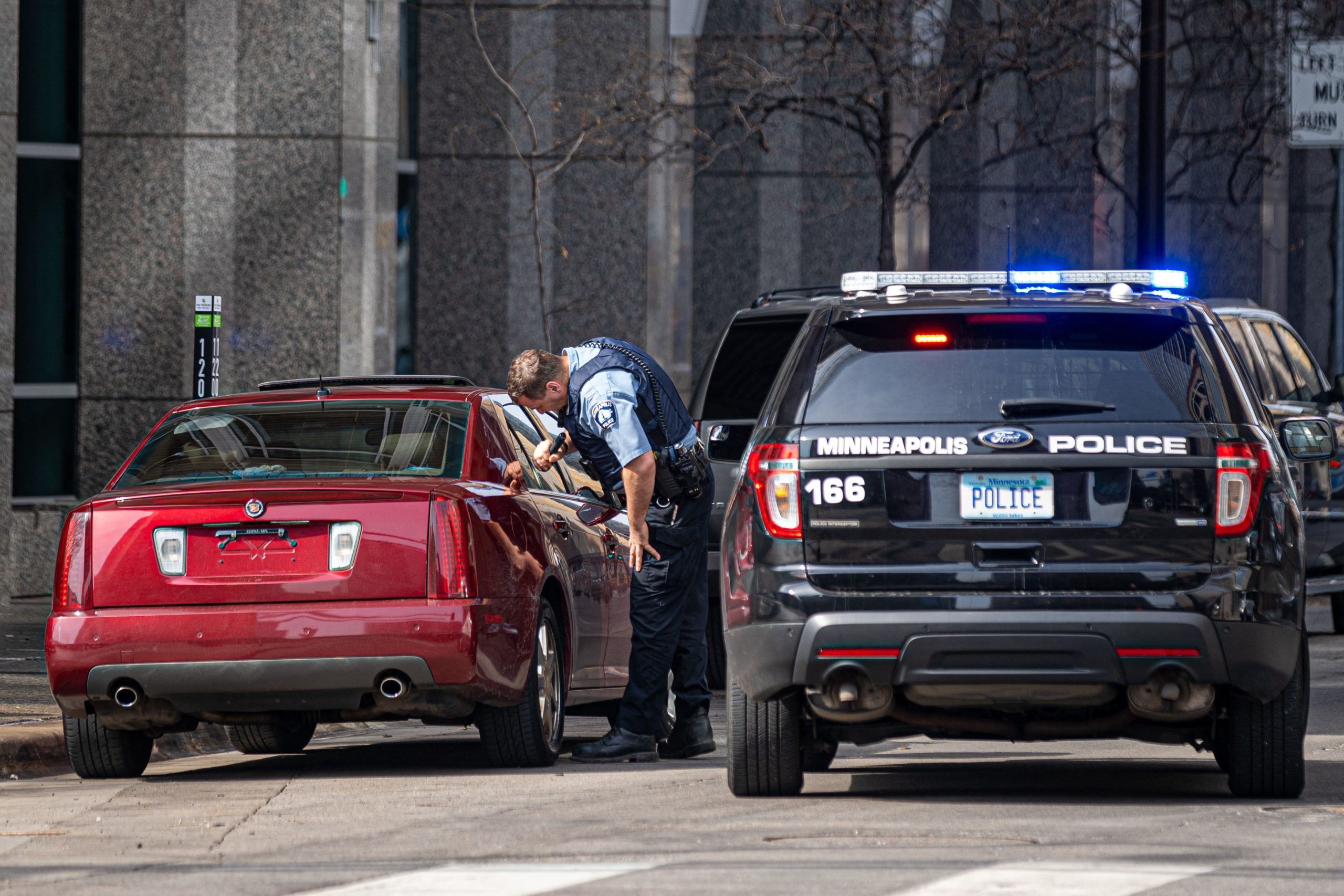 A Minneapolis Police officer checks a suspicious car without a plate parked near the Hennepin County Government Center as the jury selection begins at the trial of former police officer Derek Chauvin in Minneapolis, Minnesota on March 9, 2021. - Jury selection finally got underway on March 9 in the high-profile trial of former Minneapolis Police Department officer Derek Chauvin accused of killing George Floyd, a Black man whose death laid bare racial wounds in the United States and sparked protests across the globe. (Photo by Kerem Yucel / AFP) (Photo by KEREM YUCEL/AFP via Getty Images)