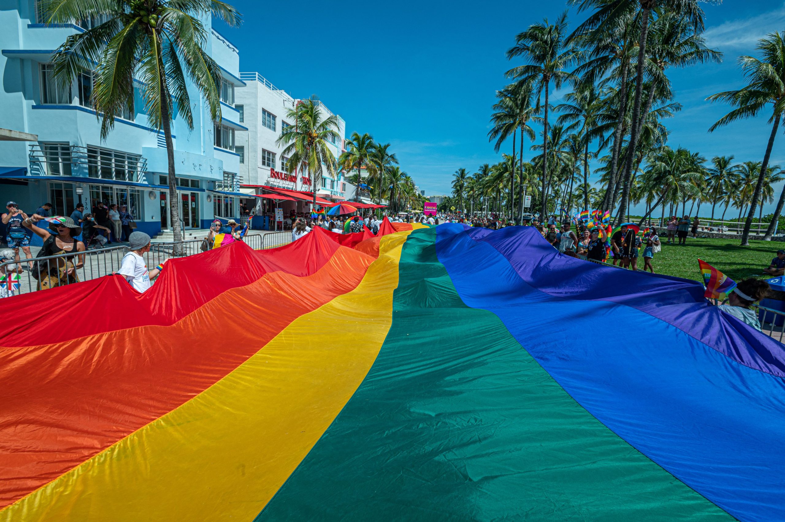 A huge multi-colored flag flies over Ocean Drive as people participate in the Pride Parade, during the Miami Beach Pride Festival, in Lummus Park, South Beach, Florida on September 19, 2021. (Photo by Giorgio Viera / AFP) (Photo by GIORGIO VIERA/AFP via Getty Images)