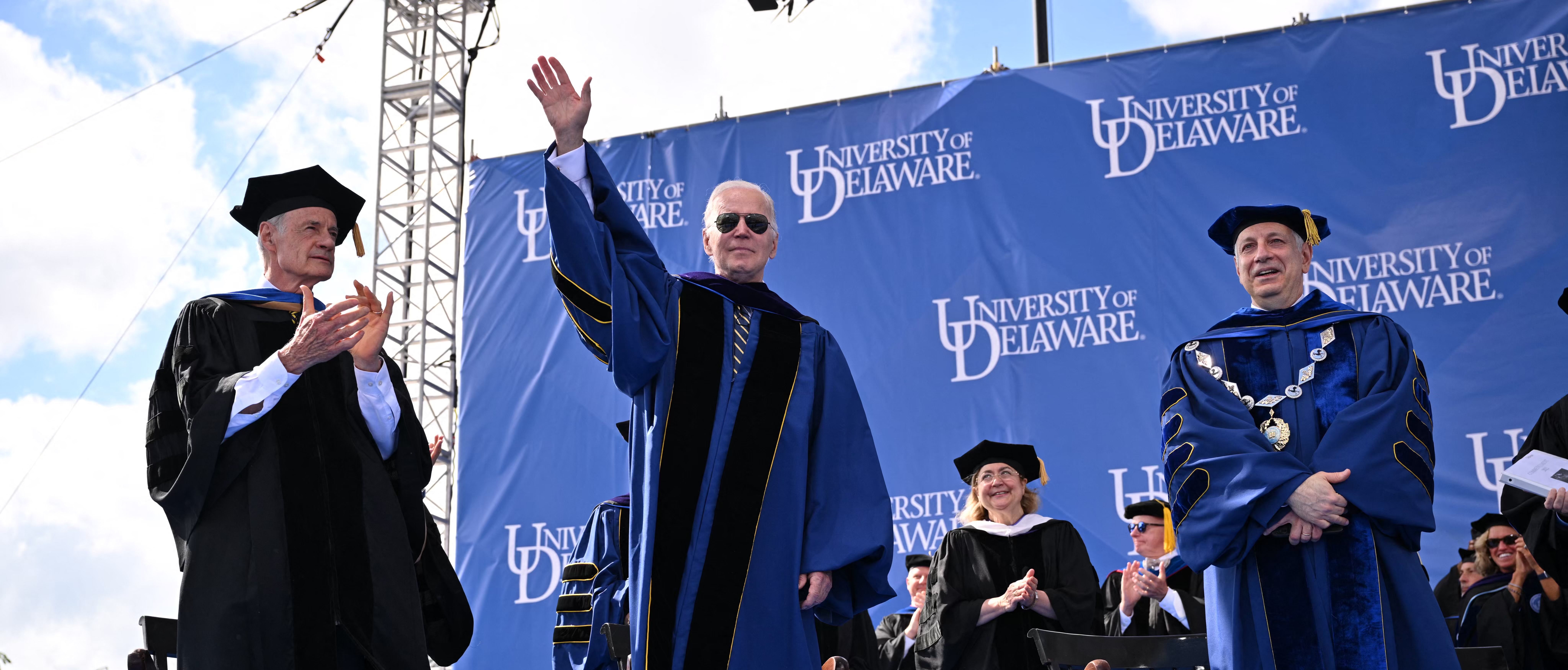 US President Joe Biden, with with University of Delaware President Dennis Assanis (R) and Senator Tom Carper (L), attends the graduation ceremony for his alma mater, the University of Delaware, at Delaware Stadium, where he will deliver the commencement address, in Newark, Delaware, on May 28, 2022.