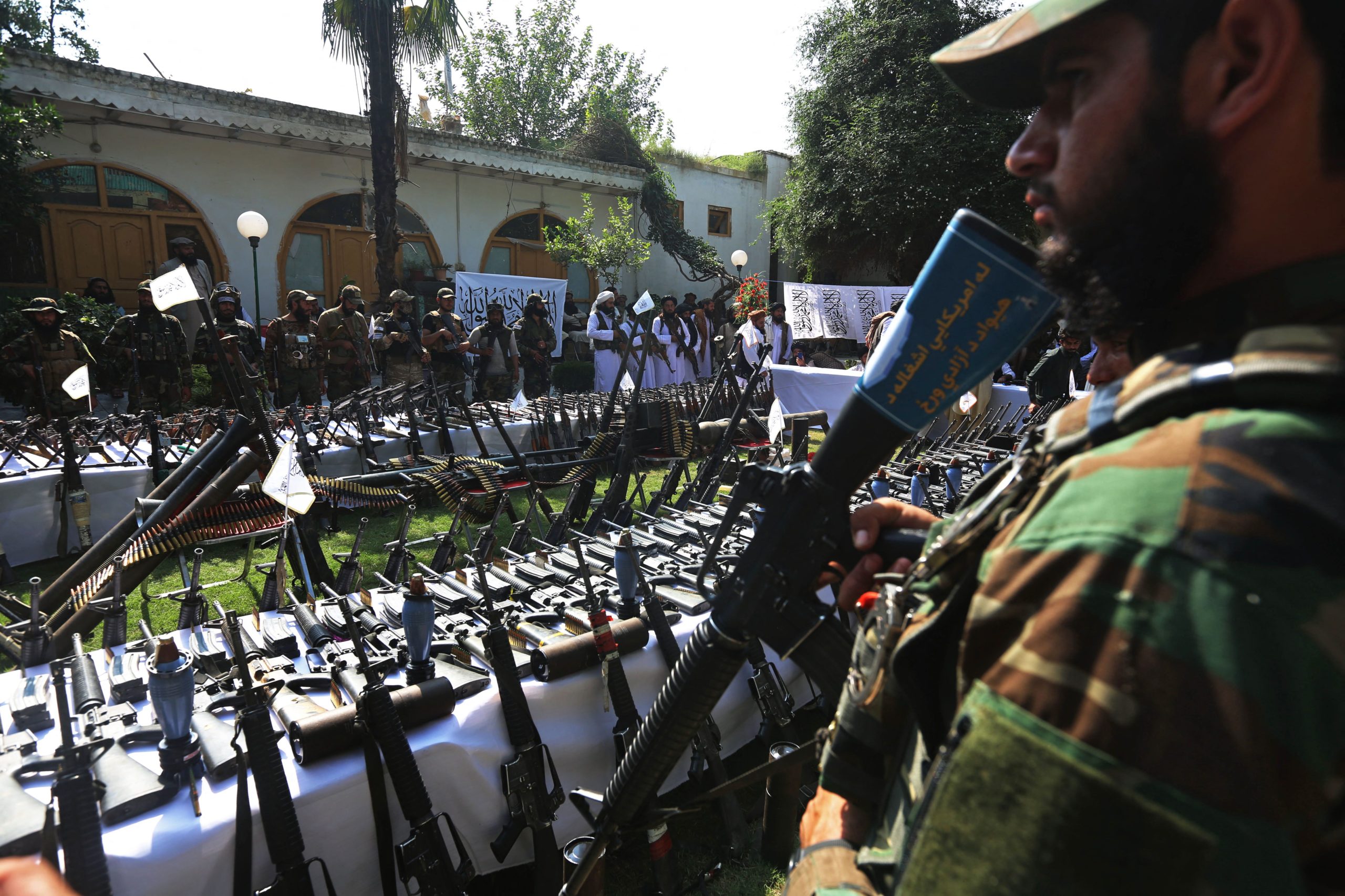 Taliban fighters stand guard next to the weapons on display for media representatives after an operation in which weapons and ammunition were seized from various locations in Asadabad of Kunar Province on September 25, 2022.