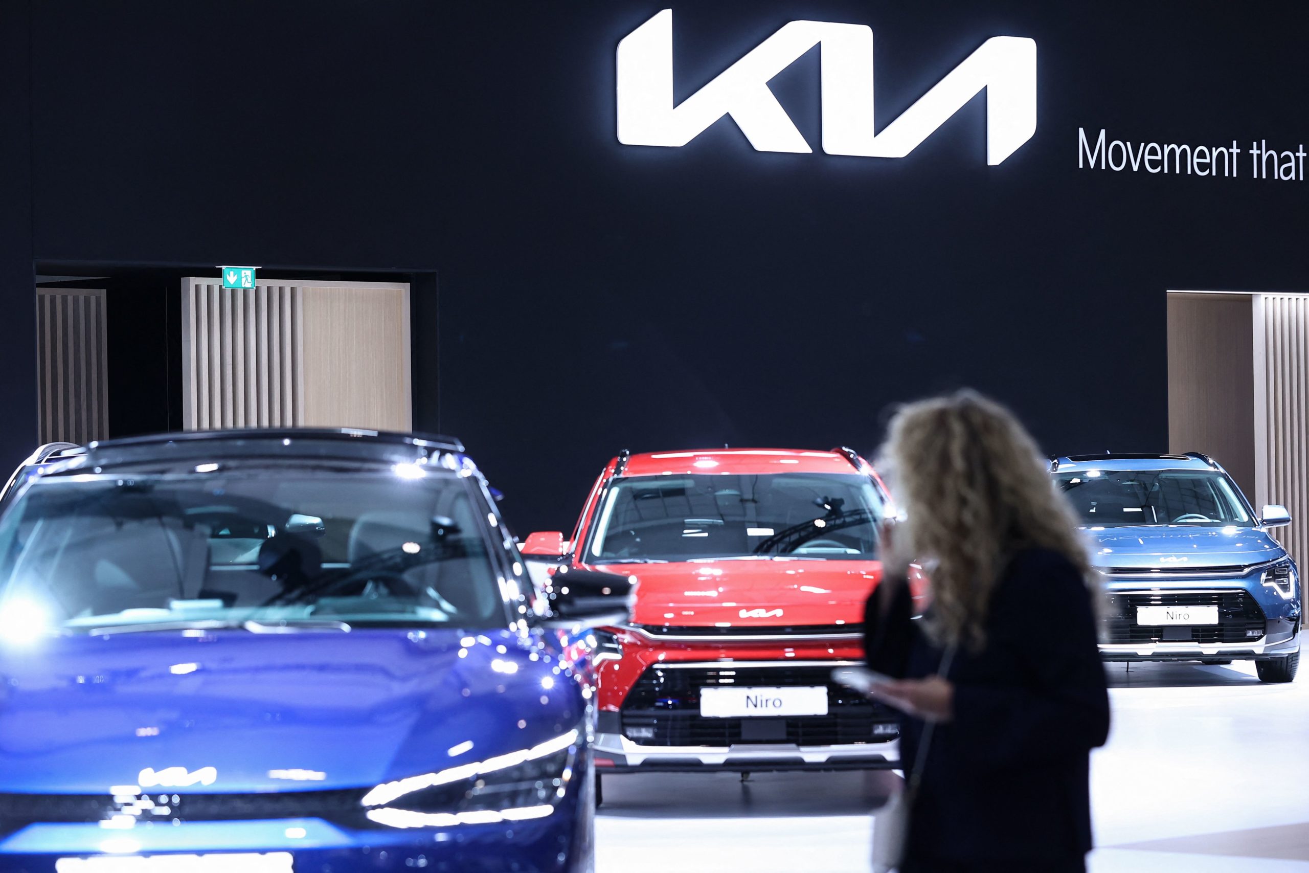 A woman visits the KIA stand during Brussels Motor Show on January 13, 2023 in Brussels. (Photo by Kenzo TRIBOUILLARD / AFP) (Photo by KENZO TRIBOUILLARD/AFP via Getty Images)