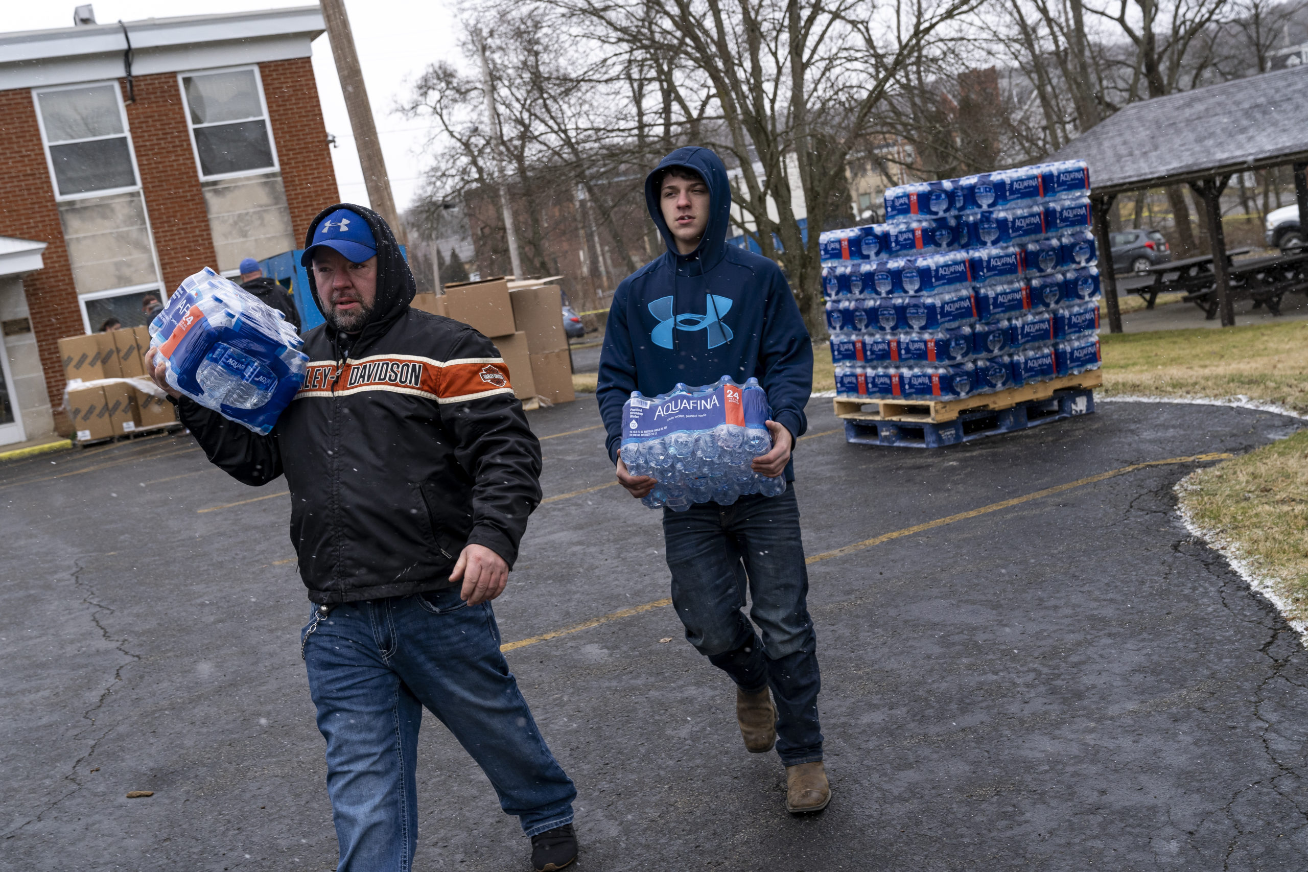 Shawn Mitchell and Braden Cianni volunteer to distribute cases of water to residents on February 17, 2023 in East Palestine, Ohio. 