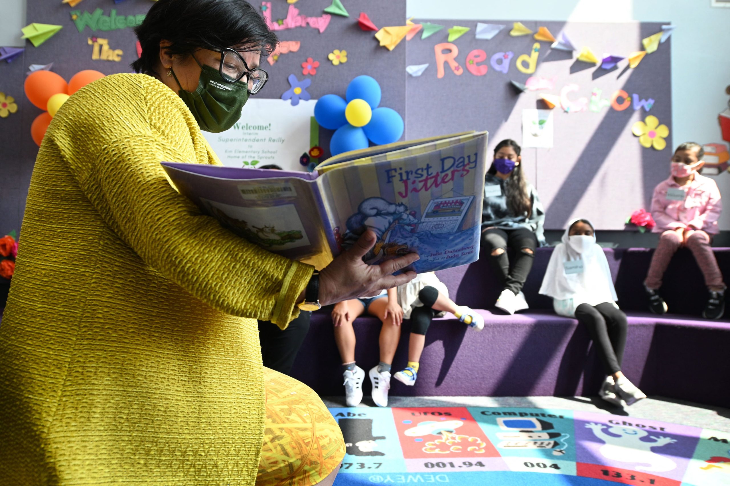 Los Angeles Unified School District (LAUSD) interim Superintendent Megan Reilly reads a book called "First Day Jitters" to students in the library at Kim Elementary School on the first day of the school year, in Los Angeles, California, August 16, 2021. - To stem the spread of Covid-19 coronavirus teachers in Los Angeles are required to be fully vaccinated against Covid-19 by October 15 and both teachers and students are required to wear masks inside school buildings. Issues wih the new "Daily Pass" health check app caused confusion and long lines on the first day back to school. (Photo by Robyn Beck / AFP) (Photo by ROBYN BECK/AFP via Getty Images)