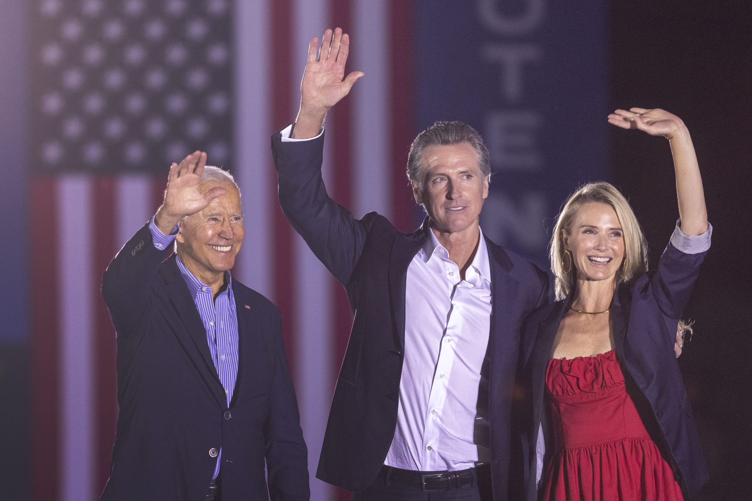 LONG BEACH, CA - SEPTEMBER 13: U.S. President Joe Biden, California Gov. Gavin Newsom and Jennifer Lynn Siebel Newsom wave to the crowd as they campaign to keep the governor in office at Long Beach City College on the eve of the last day of the special election to recall the governor on September 13, 2021 in Long Beach, California. Forty-six candidates, mostly Republicans, are attempting to overthrow the governor in the recall election a year ahead of the regularly scheduled gubernatorial vote. (Photo by David McNew/Getty Images)