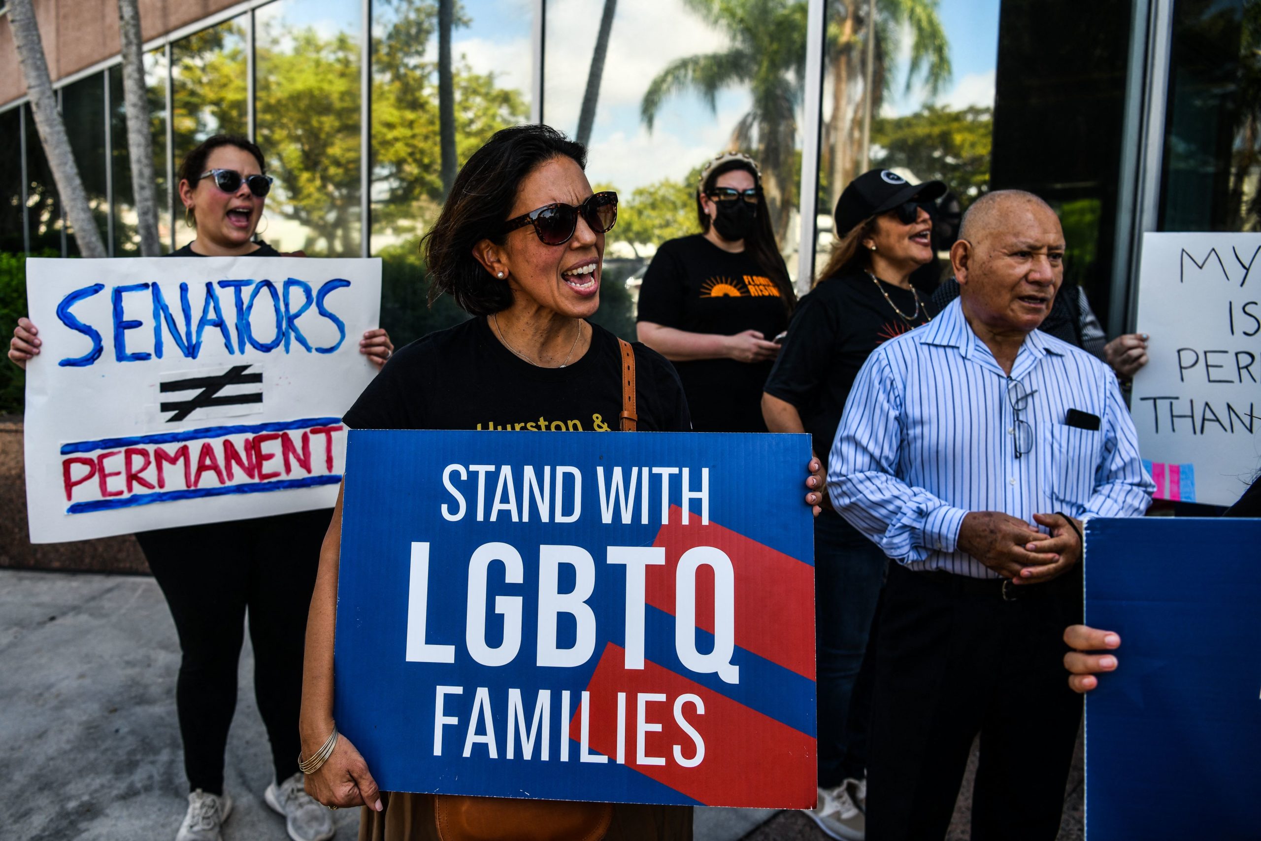 People hold placards and shout slogans as they protest outside the office of Florida State Senator Ileana Garcia in Coral Gables, Florida, on March 9, 2022. - Both the Florida Senate and House passed a bill that would limit what classrooms can teach about sexual orientation and gender identity. (Photo by CHANDAN KHANNA / AFP) (Photo by CHANDAN KHANNA/AFP via Getty Images)