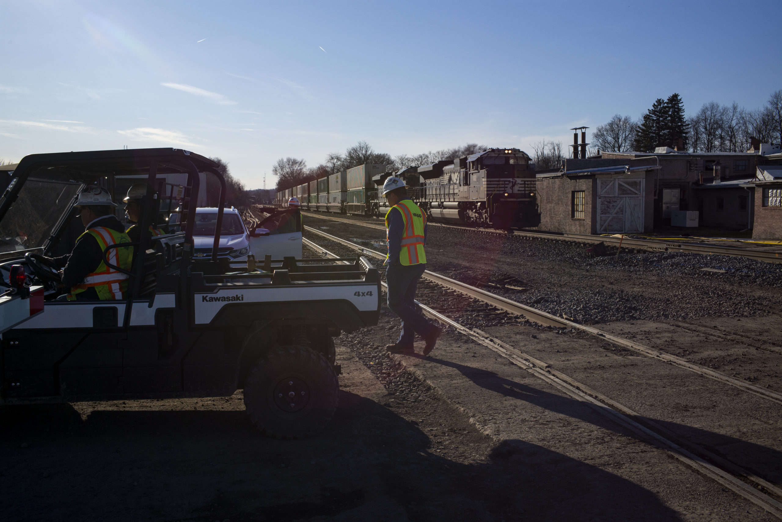 A Norfolk Southern contractor walks away from the tracks as a train approaches on March 9, 2023 in East Palestine, Ohio.