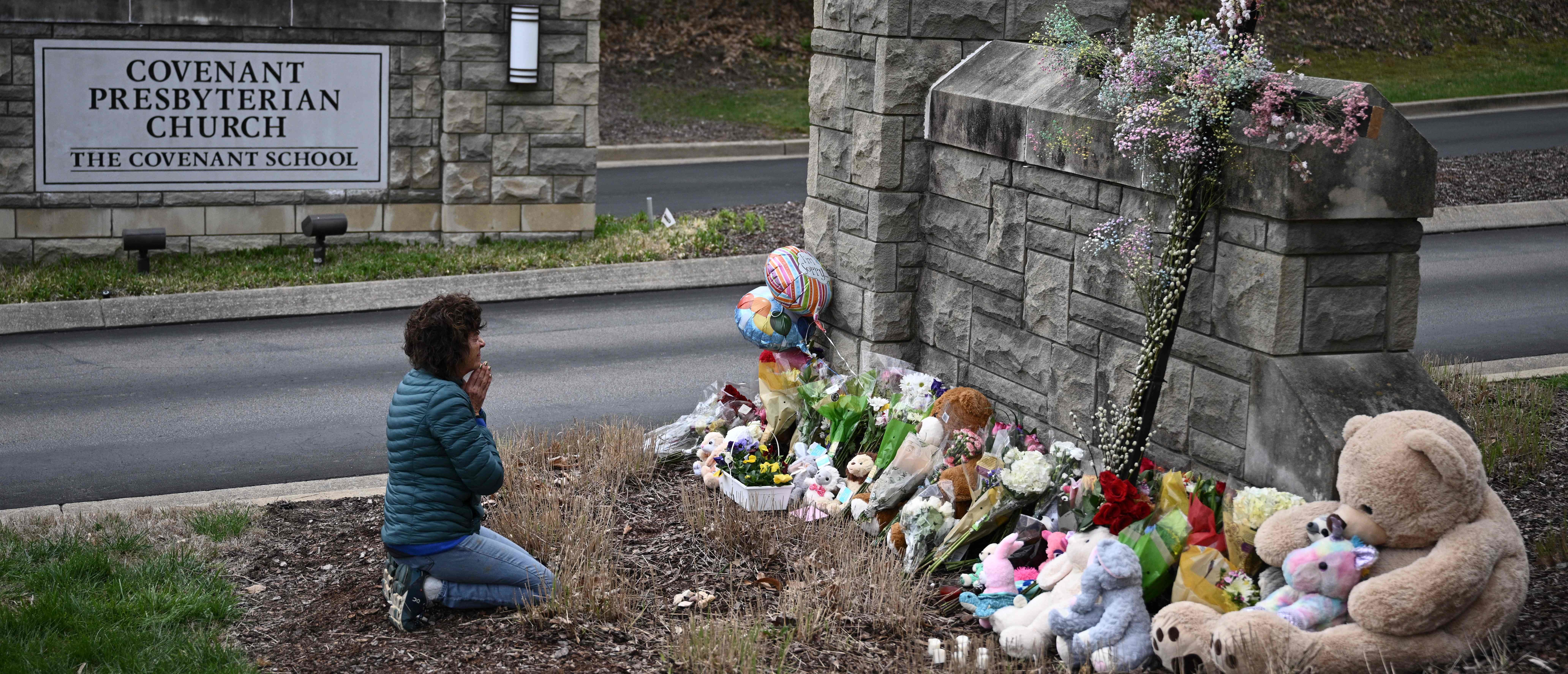 Robin Wolfenden prays at a makeshift memorial for victims outside the Covenant School building at the Covenant Presbyterian Church following a shooting, in Nashville, Tennessee, on March 28, 2023. - A heavily armed former student killed three young children and three staff in what appeared to be a carefully planned attack at a private elementary school in Nashville on March 27, before being shot dead by police. Chief of Police John Drake named the suspect as Audrey Hale, 28, who the officer later said identified as transgender. (Photo by Brendan SMIALOWSKI / AFP) (Photo by BRENDAN SMIALOWSKI/AFP via Getty Images)