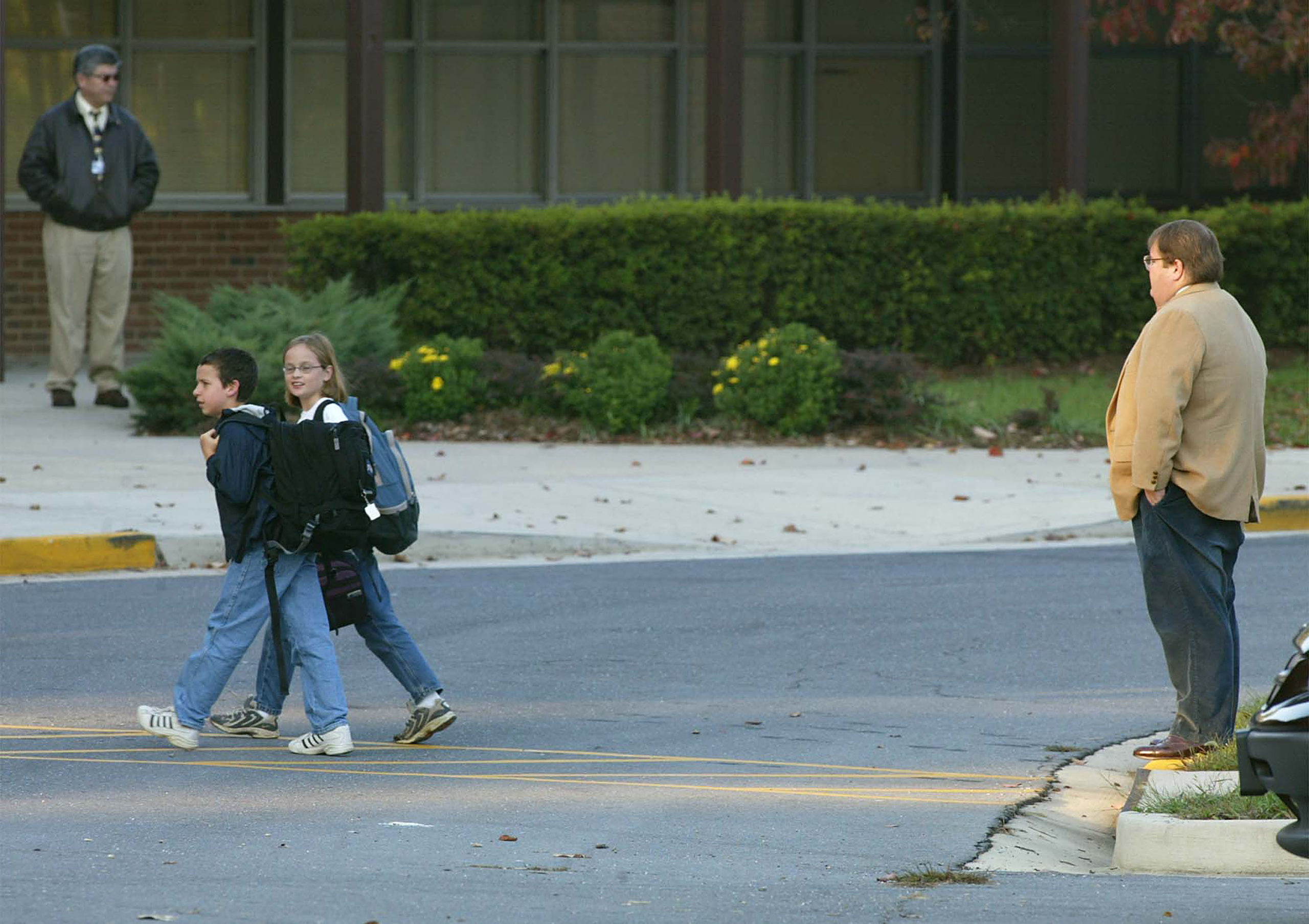 A parent drops off his children at Strathmore Elementry School October 23, 2002 in Aspen Hill, Maryland. Strathmore is located less than a mile from where a bus driver was shot and killed October 23. Montgomery County Police Chief Charles Moose reported to the public that the sniper threathened children in a note. Schools in the area are in a Code Blue lock down mode, banning all outdoor activities. (Photo by Mark Wilson/Getty Images)