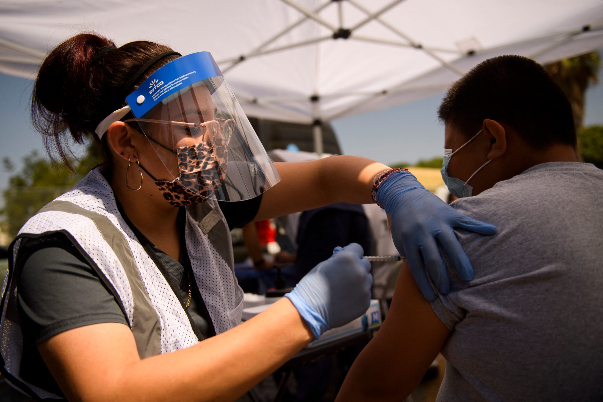 A 12-year-old receives a first dose of the Pfizer Covid-19 vaccine at a mobile vaccination clinic during a back to school event offering school supplies, Covid-19 vaccinations, face masks, and other resources for children and their families at the Weingart East Los Angeles YMCA in Los Angeles, California on August 7, 2021. (Photo by Patrick T. FALLON / AFP) (Photo by PATRICK T. FALLON/AFP via Getty Images)