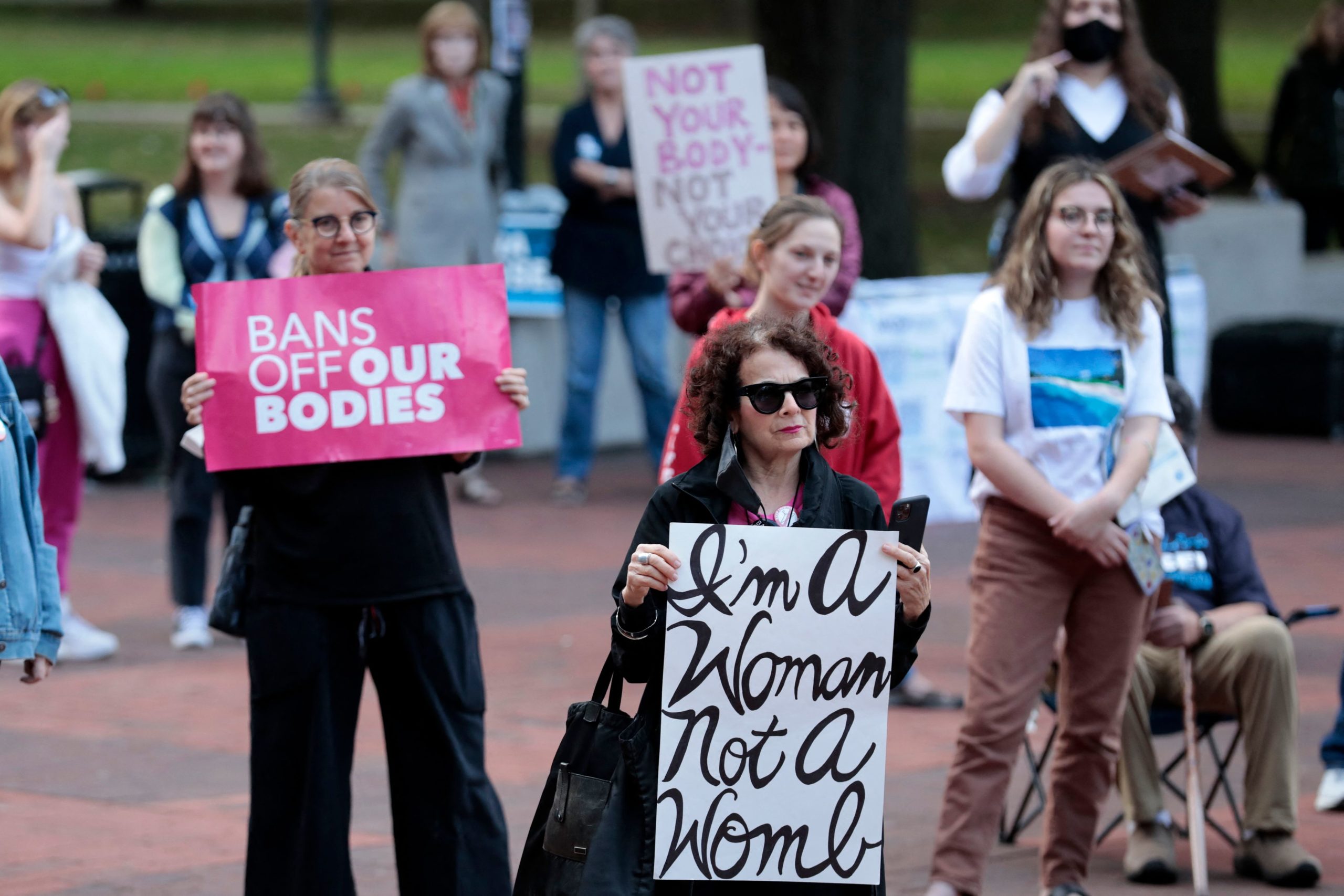 Demonstrators hold signs "Bans Off Our Bodies" as they protest during a rally for reproductive freedom and voting rights on the campus of the University of Michigan in Ann Arbor, Michigan on October 3, 2022.