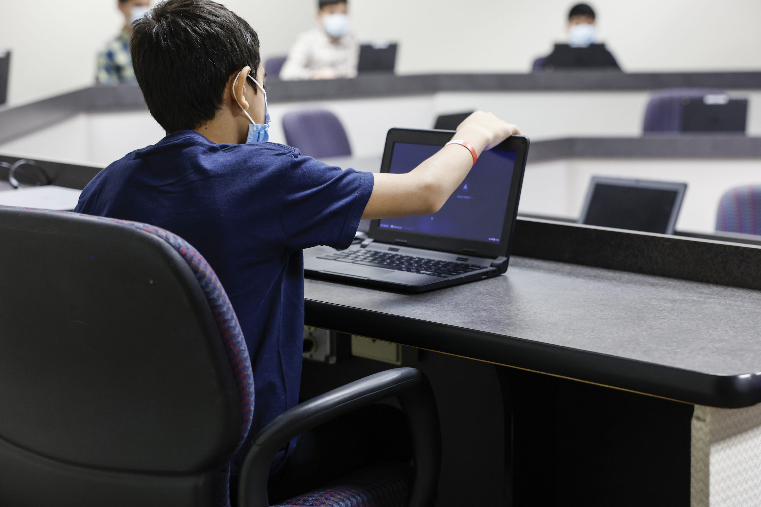 A young Afghan boy looks at a laptop in a computer classroom in the National Conference Center (NCC), which in recent months has been redesigned to temporarily house Afghan nationals on August 11, 2022 in Leesburg, Virginia. Operation Allies Welcome an initiative coordinated by both the Department of Defense and U.S. Department of Homeland Security, has turned the NCC into a hotel like location where Afghan nationals who recently left Afghanistan can begin the process of resettling in the United States. This action is part of the organizations second phase in relocating vulnerable Afghan refugees, since the Taliban retook control of the government in Afghanistan. (Photo by Anna Moneymaker/Getty Images)