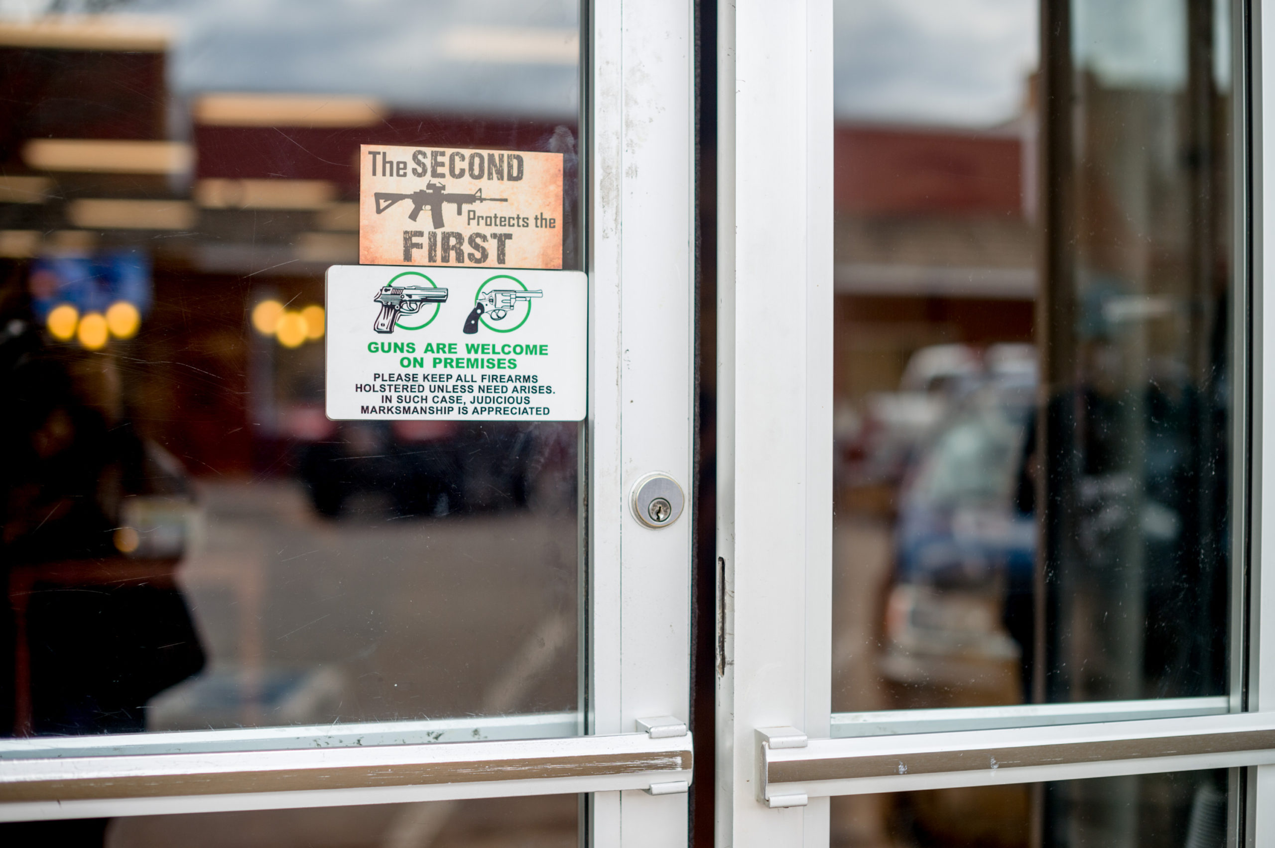 Signs on the door handles at Shooters Grill in Rifle, Colorado on April 24, 2018. - Lauren Boebert opened Shooters Grill in 2013 with her husband Jason in the small town of Rifle, Colorado, the only city in the United States named after a gun according to them. Shortly after Boebert opened the restaurant, there was a murder in the alley behind it. Boebert went next door to the Tradesmen Gun Store and Pawnshop to speak to the owner, Edward Wilks. Wilks explained to her that you dont need a permit in the state of Colorado to open carry. The next day she started carrying a gun with her. The majority of her staff carries, while it is not a requirement to work there she encourages them to do so if they feel comfortable with it. Customers are also welcome to carry firearms on them as well. The restaurants theme remained heavily country western but revolves alot around the theme of the Second Amendment as well. (Photo by EMILY KASK / AFP) (Photo credit should read EMILY KASK/AFP via Getty Images)