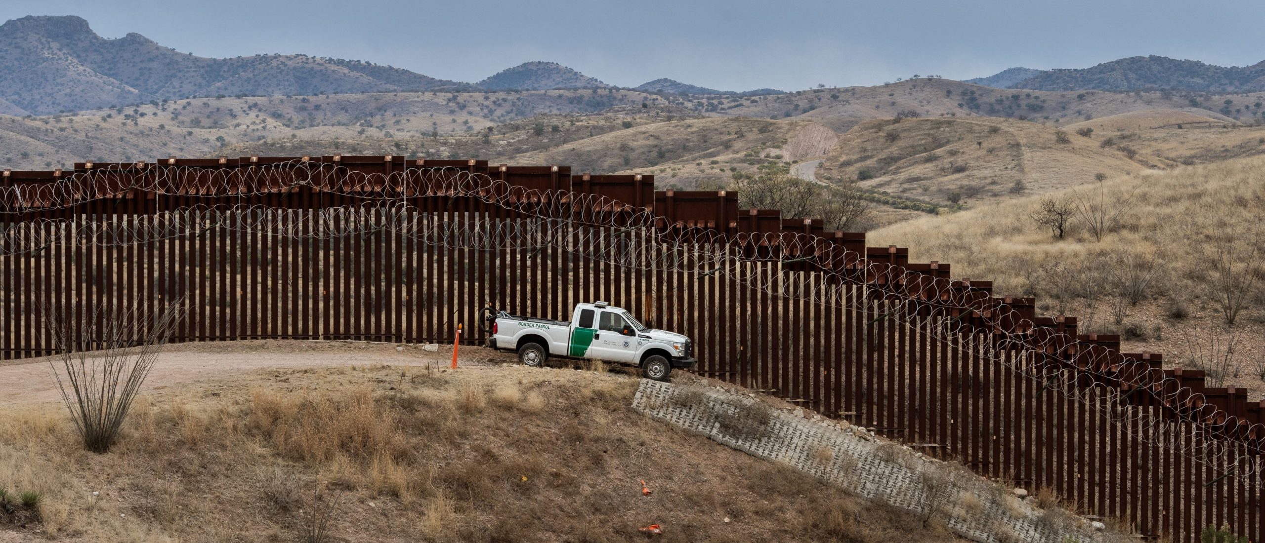 TOPSHOT - A Border Patrol officer sits inside his car as he guards the US/Mexico border fence, in Nogales, Arizona, on February 9, 2019. (Photo by Ariana Drehsler / AFP) (Photo by ARIANA DREHSLER/AFP via Getty Images)