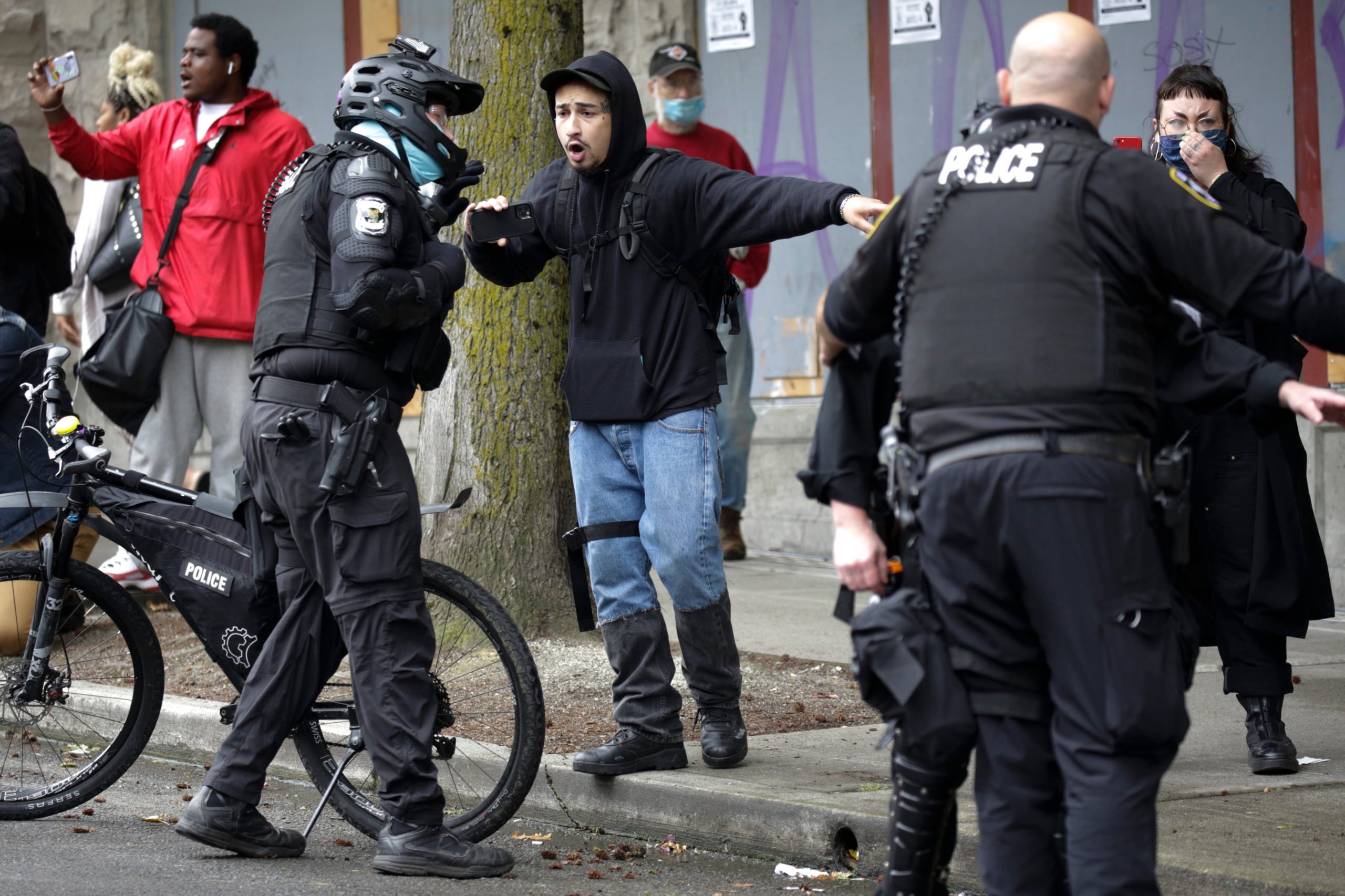 A man yells at Seattle Police as they arrest demonstrators who were blocking the intersection of East Pine Street and 11th Avenue after police cleared the Capitol Hill Occupied Protest (CHOP) and retook the department's East Precinct in Seattle, Washington on July 1, 2020. (Photo by Jason Redmond / AFP) (Photo by JASON REDMOND/AFP via Getty Images)