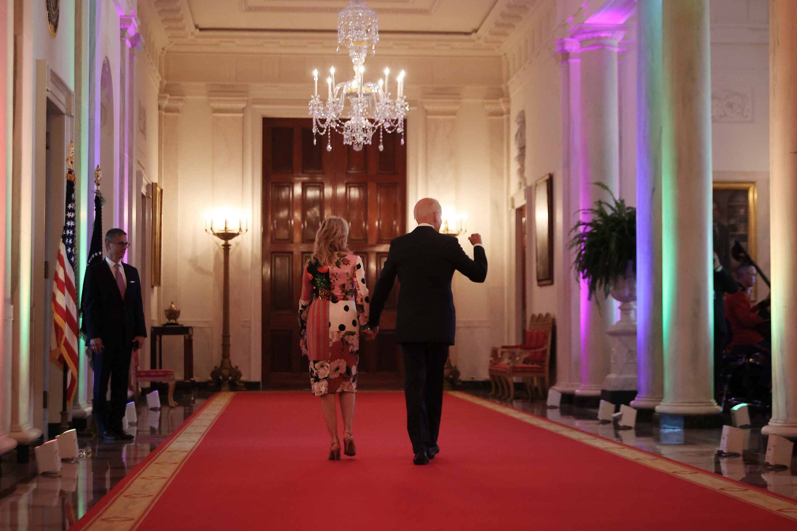 WASHINGTON, DC - JUNE 25: U.S. President Joe Biden and first lady Jill Biden walk through the Cross Hall lit with rainbow colors following an event commemorating LGBTQ+ Pride Month in the East Room of the White House on June 25, 2021 in Washington, DC. Biden celebrated the accomplishments of past and present LGBTQ+ public service leaders and said there was still more work to be done. (Photo by Chip Somodevilla/Getty Images)