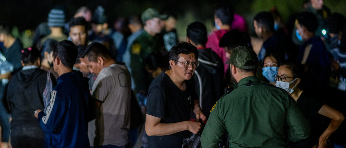 ROMA, TEXAS - MAY 05: Chinese migrants speak to a border patrol officer before being processed after they crossed the Rio Grande into the U.S. on May 05, 2022 in Roma, Texas. Texas Gov. Greg Abbott's "Operation Lone Star" directed approximately 10,000 members of the national guard to assist law enforcement with patrol and border apprehensions. The operation is expected to receive another $500 million in further securing the southern border. Towns along the southern border continue making preparations as Title 42 is scheduled to come to an end on May 23rd. (Photo by Brandon Bell/Getty Images)