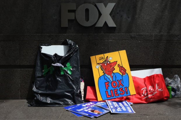 NEW YORK, NEW YORK - JUNE 14: Signs are seen on the ground in front of Fox Network signage as people gather for "Truth Tuesday" as they participate in a "Fox can't handle the truth" protest outside Fox News headquarters on June 14, 2022 in New York City. Rise and Resist advocates gathered for their weekly "Truth Tuesday" protest at the Fox News headquarters to discuss the cable news network's coverage of the January 6th hearings. Fox News was the only major cable news network to not air the January 6 committee's first prime time hearing; instead it aired the shows of Tucker Carlson, Sean Hannity and Laura Ingraham commercial free. The network did carry the second hearing live on Monday morning. (Photo by Michael M. Santiago/Getty Images)