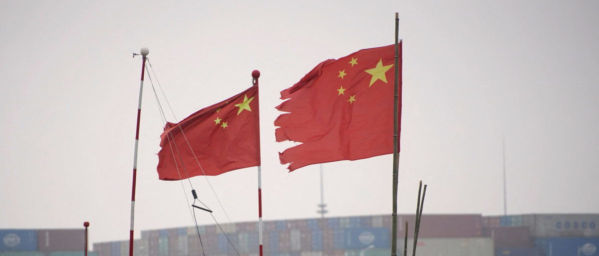FILE PHOTO: Chinese flags flutter near containers stacked at the Yangshan Deep Water Port in Shanghai, China January 13, 2022. Picture taken January 13, 2022. REUTERS/Aly Song/File Photo