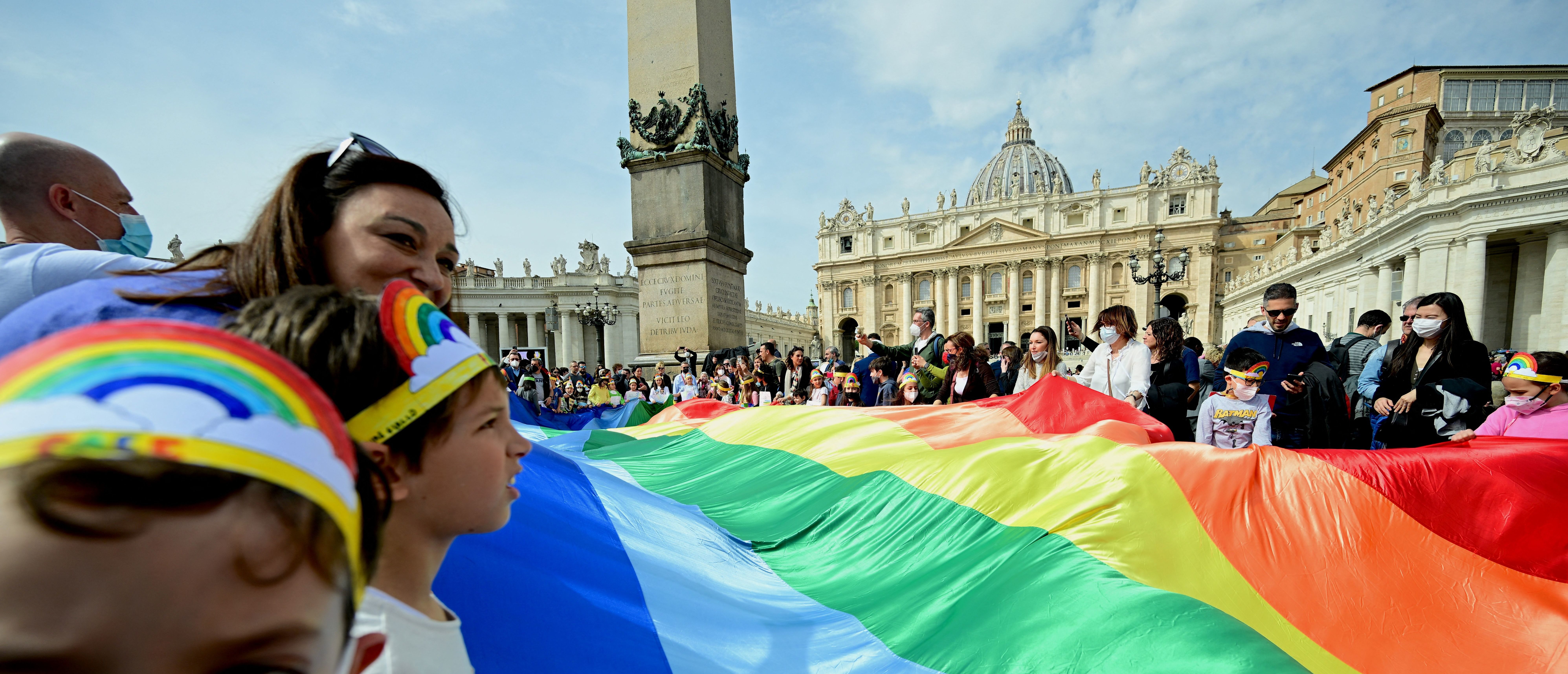 TOPSHOT - Onlookers hold a rainbow flag as Pope Francis speaks to the crowd during his Angelus prayer from the window of the apostolic palace overlooking St Peter's Square at the Vatican, on March 27, 2022. (Photo by VINCENZO PINTO/AFP via Getty Images)