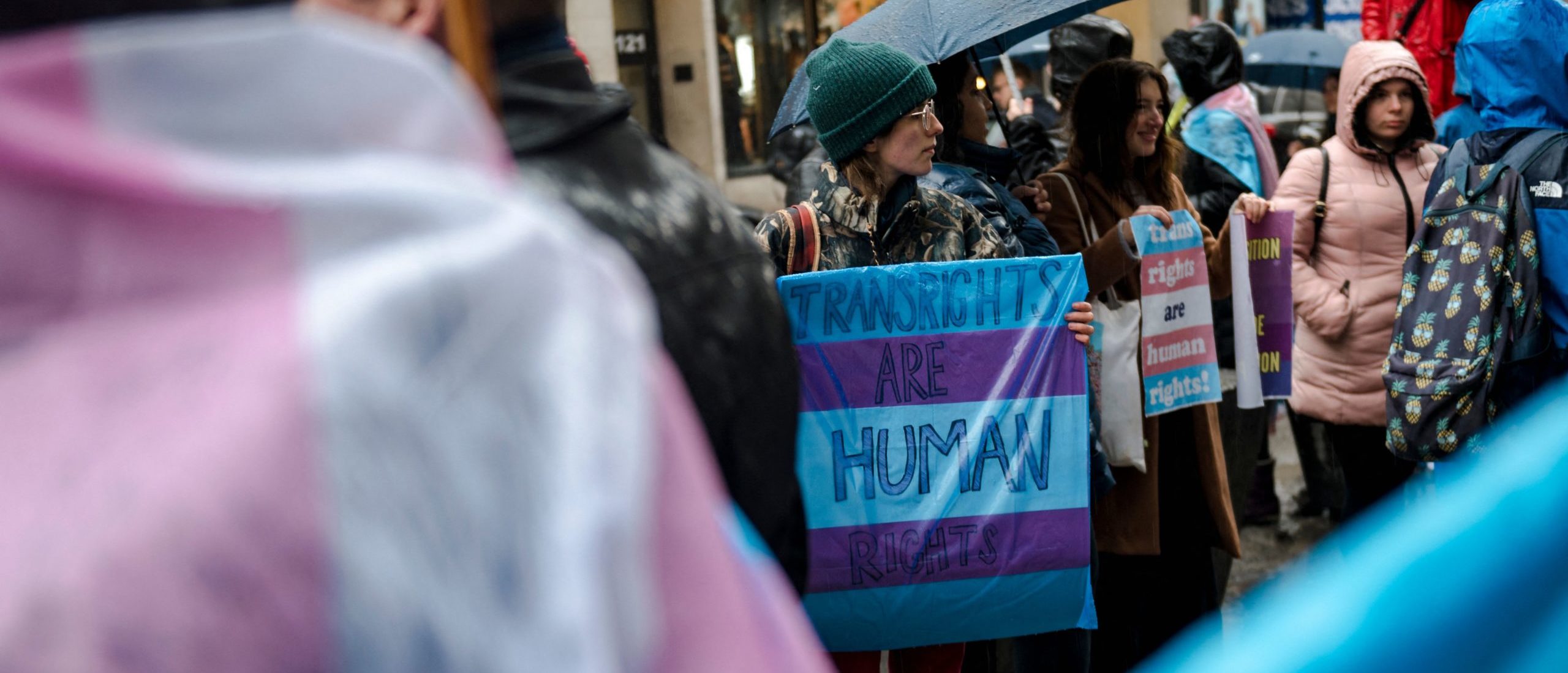 A person holds a sign reading "Trans Rights are Human Rights" as LGBTQ activists protest on March 17, 2023, in front of the US Consulate in Montreal, Canada, calling for transgender and non-binary people be admitted into Canada. - According to police services, some 200 people gathered in the rain to show support for the trans community in the United States. (Photo by ANDREJ IVANOV / AFP) (Photo by ANDREJ IVANOV/AFP via Getty Images)