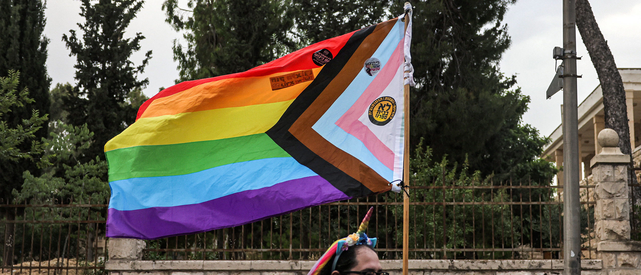 A person marches with a combined rainbow and transgender flag during the 21st annual Jerusalem Pride Parade in Jerusalem on June 1, 2023. (Photo by AHMAD GHARABLI / AFP) (Photo by AHMAD GHARABLI/AFP via Getty Images)