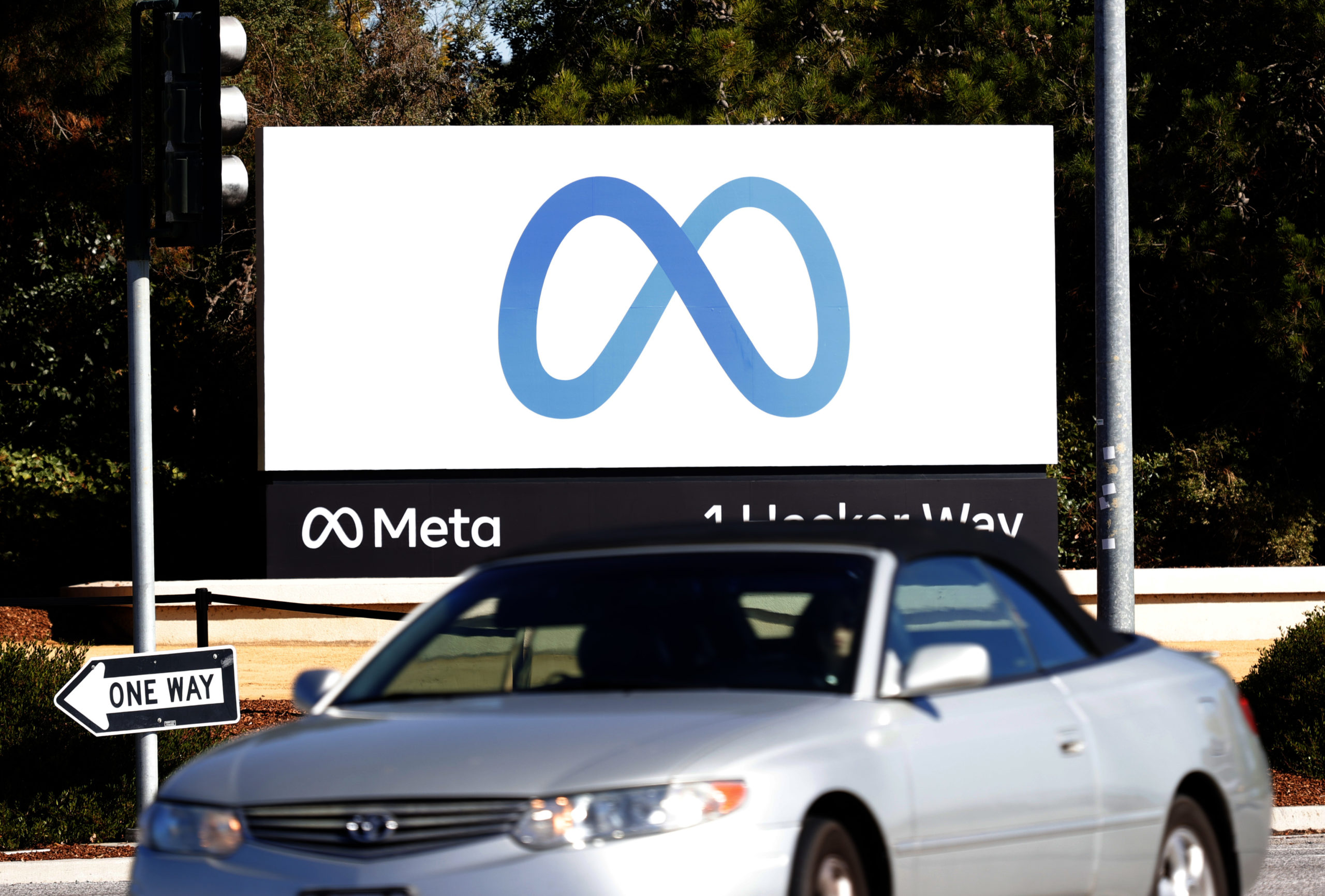 A car drives by a new logo and the name 'Meta' on the sign in front of Facebook headquarters on October 28, 2021 in Menlo Park, California.