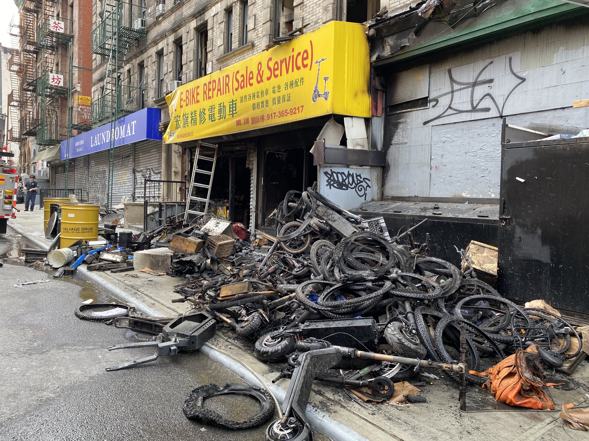 JUNE 20, 2023 - A pile of burned bikes and scooters lie outside HQ E-Bike Repair in New York City's Chinatown, following a blaze that spread to the upstairs apartment complex, killing four and leaving two in critical condition. (FDNY/Twitter)