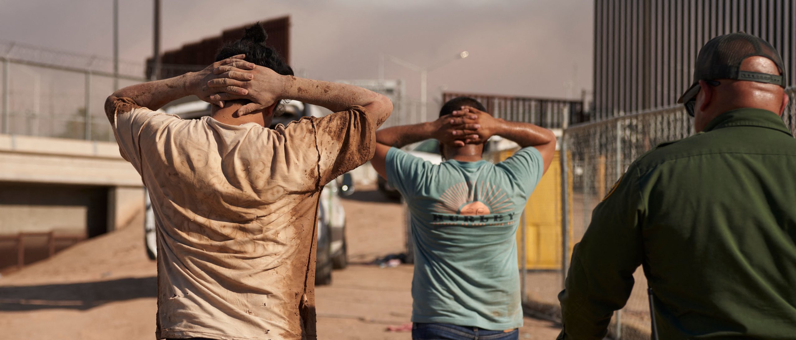 Migrants apprehended by US Border Patrol agents, walk with their hands on their heads after entering the United States illegally from Mexico on October 6, 2022 in Calexico, California. (Photo by ALLISON DINNER/AFP via Getty Images)