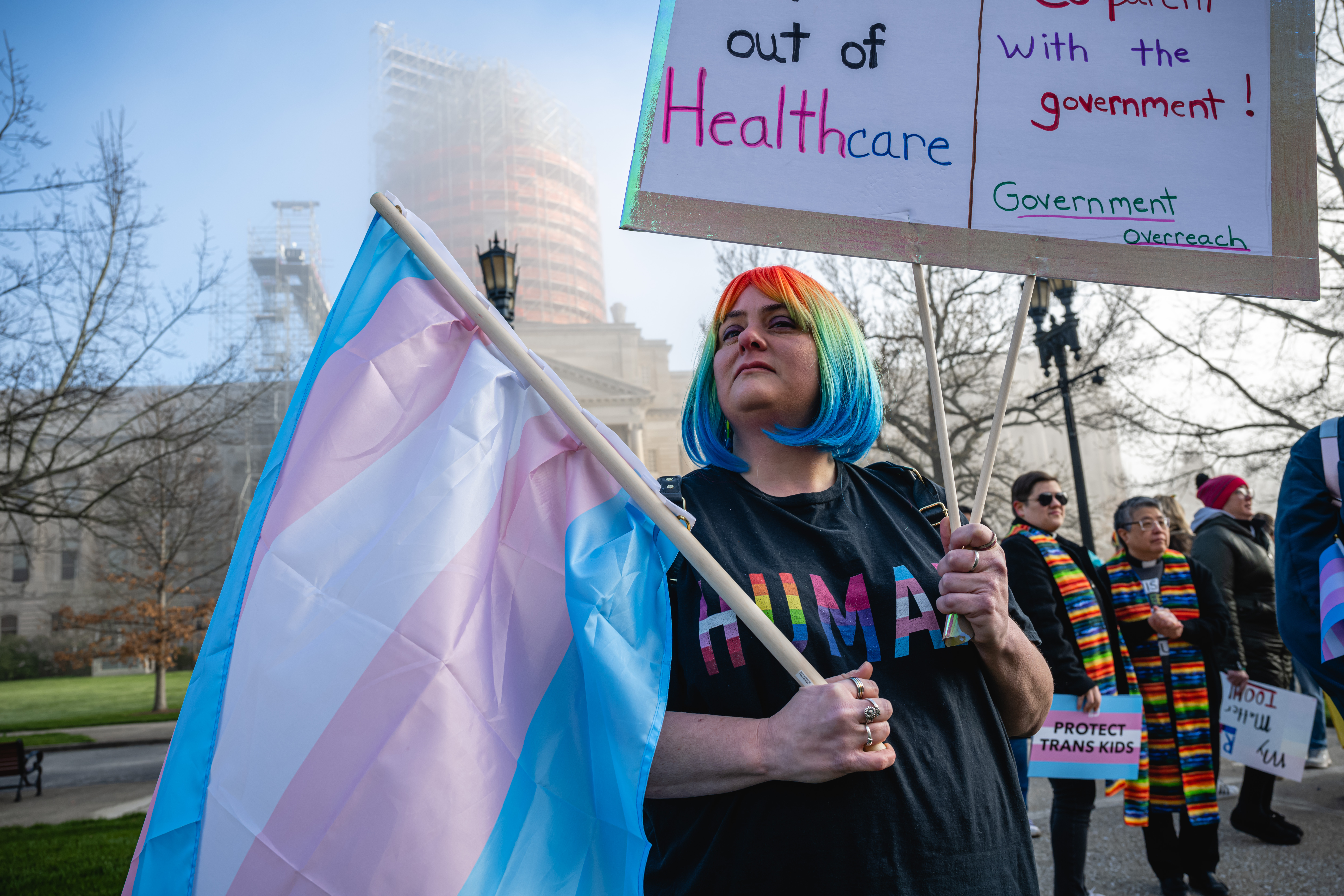 Sarah Newton stands with a trans pride flag during a rally to protest the passing of SB 150 on March 29, 2023 at the Kentucky State Capitol in Frankfort, Kentucky. SB 150, which was proposed by State Senator Max Wise (R-KY), is criticized by many as a "Don't Say Gay" bill and was vetoed by Kentucky Governor Andy Beshear during the General Assembly. Lawmakers may override this veto, passing the bill into law. (Photo by Jon Cherry/Getty Images)