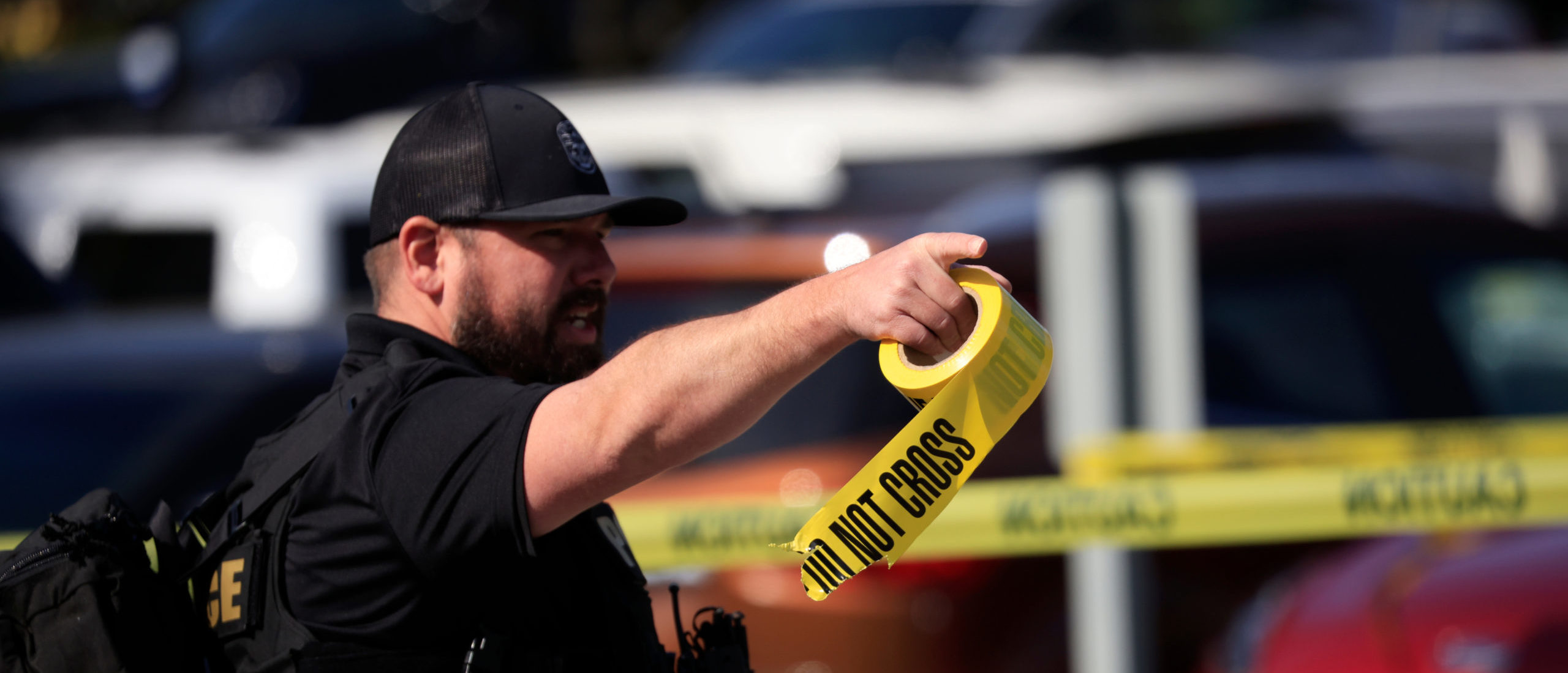 LOUISVILLE, KY - APRIL 10: A law enforcement officer carries a roll of crime scene tape after a gunman opened fire at the Old National Bank building on April 10, 2023 in Louisville, Kentucky. According to reports, there are multiple fatalities and injuries. The shooter died at the scene.
