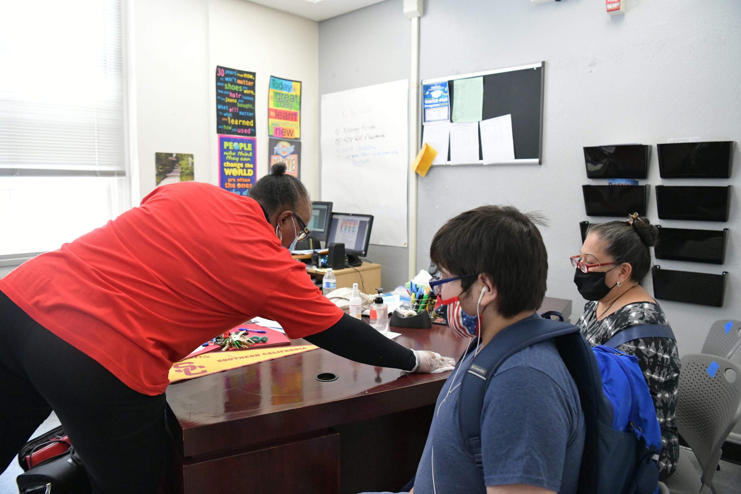 Assistant Principal Catrisa Booker (L) disinfects a desk at Hollywood High School on August 13, 2020 in Hollywood, California. With over 734,000 enrolled students, the Los Angeles Unified School District is the largest public school system in California and the 2nd largest public school district in the United States. With the advent of COVID-19, blended learning, or combined online and classroom learning, will become the norm for the coming school year. (Photo by Rodin Eckenroth/Getty Images)