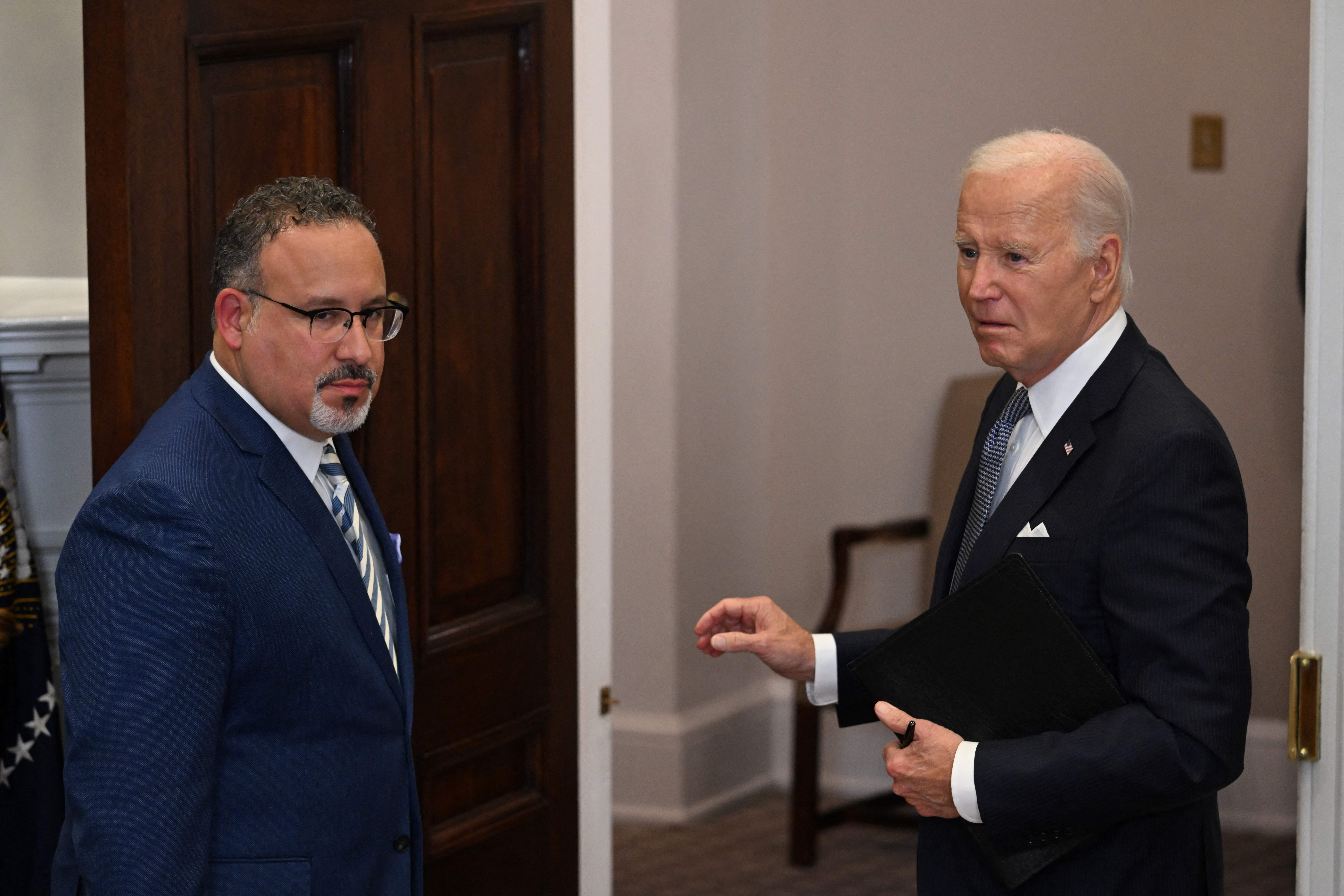 US President Joe Biden and Education Secretary Miguel Cardona leave after speaking about the US Supreme Court's decision overruling student debt forgiveness as Education Secretary Miguel Cardona looks on in the Roosevelt Room of the White House in Washington, DC, on June 30, 2023. The court said Biden had overstepped his powers in cancelling more than $400 billion in debt, in an effort to alleviate the financial burden of education that hangs over many Americans decades after they finished their studies. (Photo by Jim WATSON / AFP) (Photo by JIM WATSON/AFP via Getty Images)
