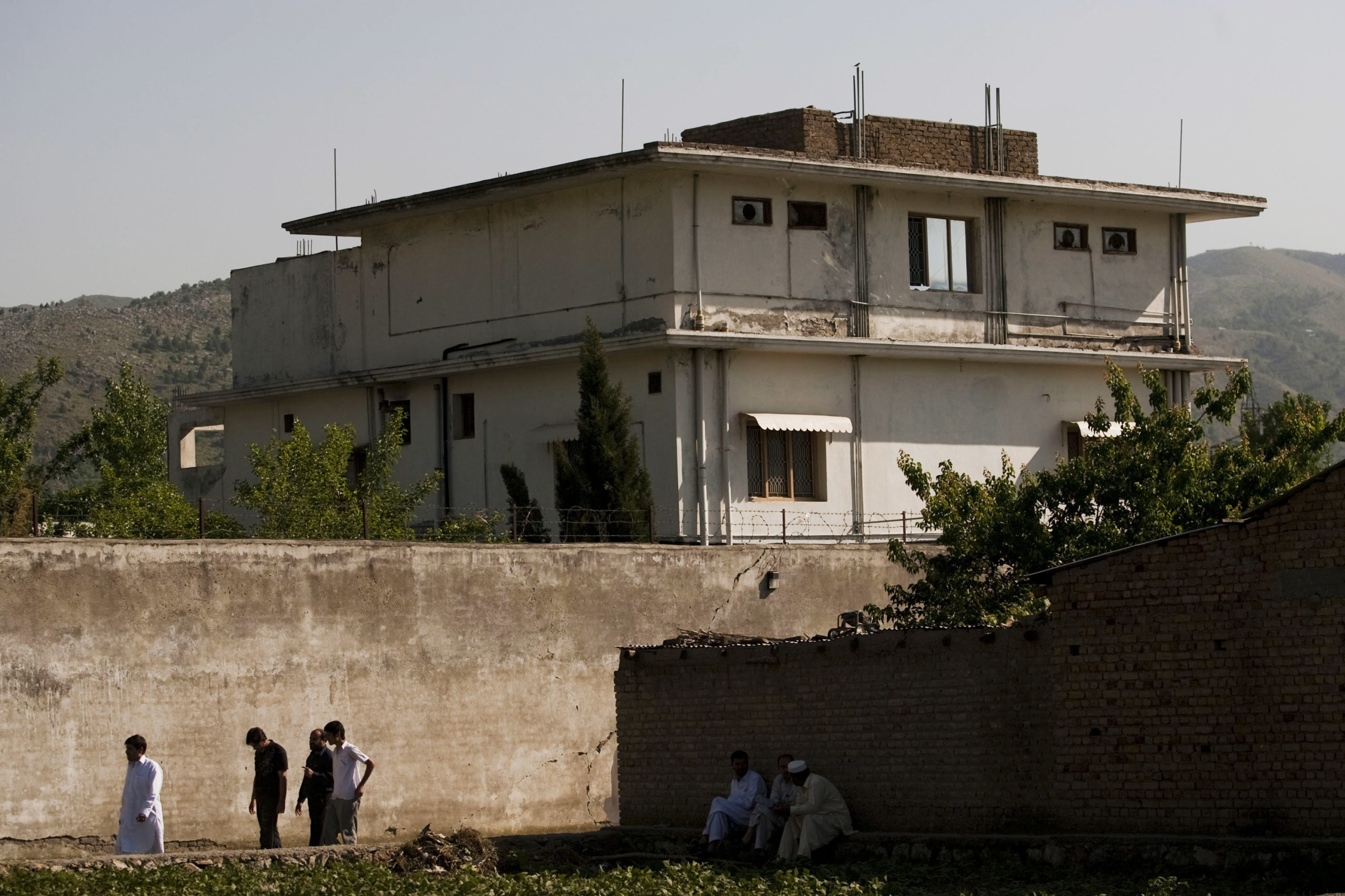 ABBOTTABAD, PAKISTAN - MAY 3: People walk past Osama Bin Laden's compound, where he was killed during a raid by U.S. special forces, May 3, 2011 in Abottabad, Pakistan. Bin Laden was killed during a U.S. military mission May 2, at the compound. According to reports May 4, 2011, the Obama administration has decided not to release photographs of Bin Laden's body. (Photo by Getty Images)