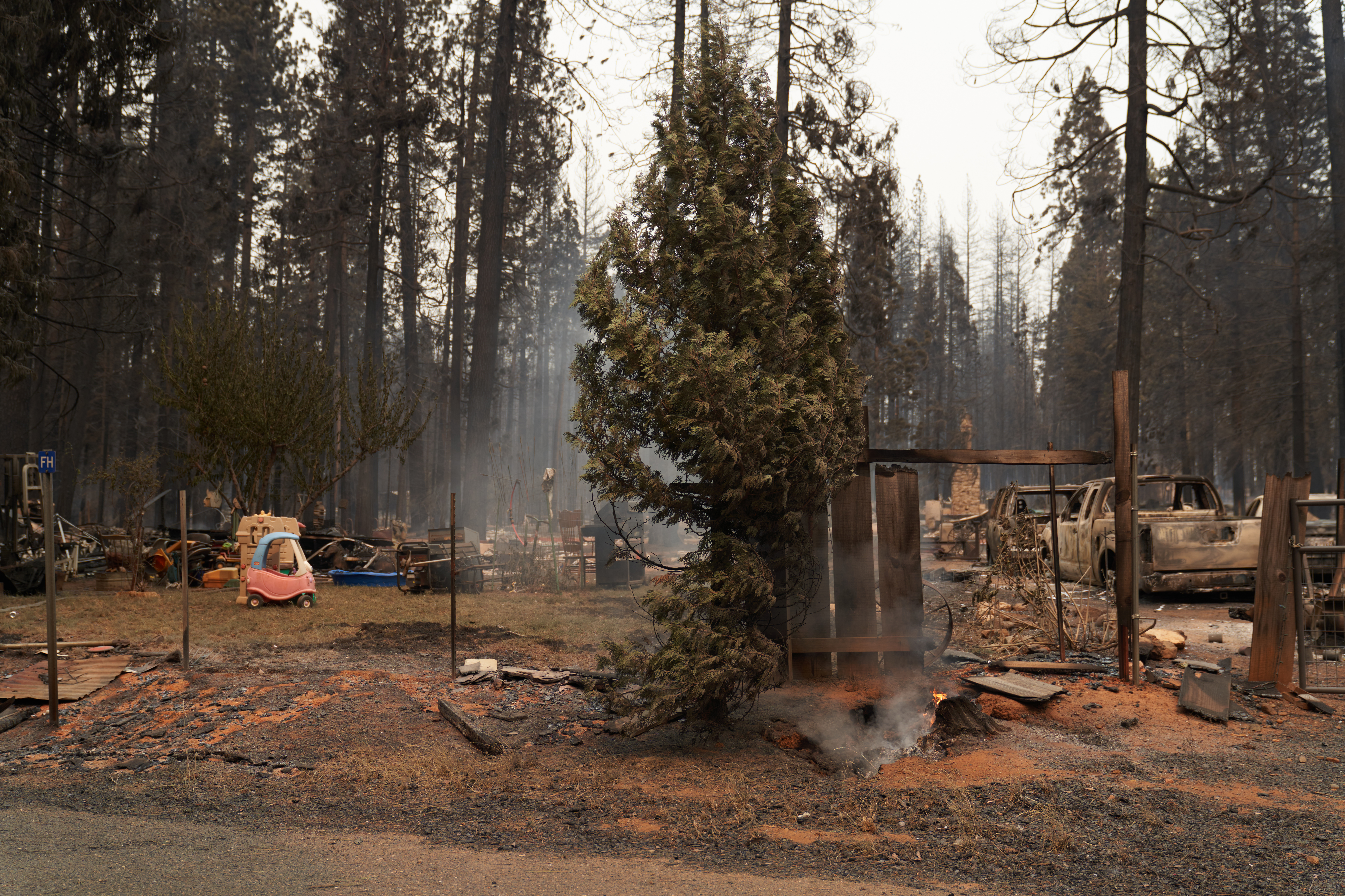 GRIZZLY FLATS, CA - AUGUST 18: A residential home is burnt with a child's toy car still intact on August 18, 2021 in Grizzly Flats, California. The Caldor Fire raged without containment through rugged forested areas of El Dorado County destroying structures as it grew to over 50,000 acres. (Photo by Allison Dinner/Getty Images)