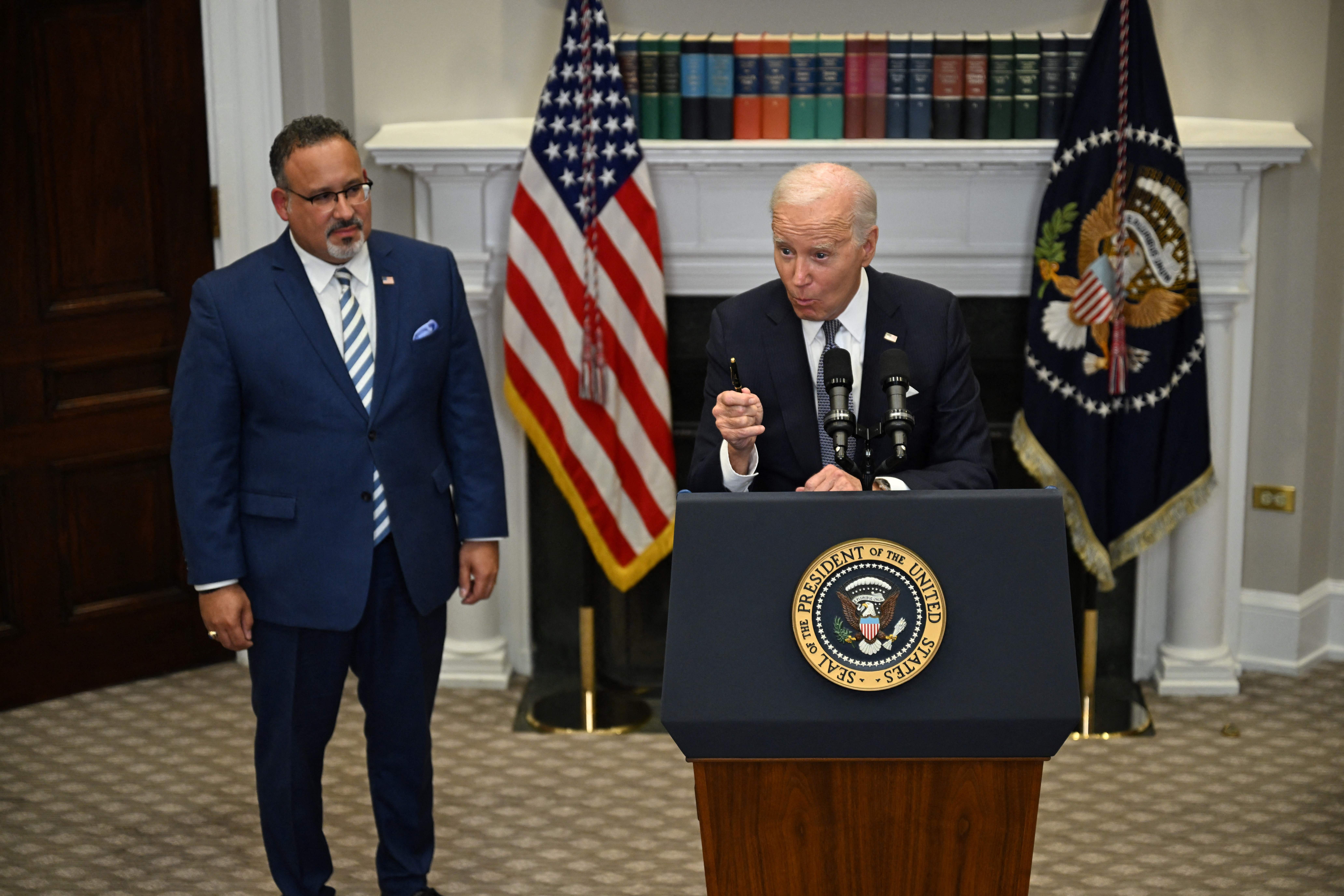 US President Joe Biden speaks about the US Supreme Court's decision overruling student debt forgiveness as Education Secretary Miguel Cardona looks on in the Roosevelt Room of the White House in Washington, DC, on June 30, 2023. The court said Biden had overstepped his powers in cancelling more than $400 billion in debt, in an effort to alleviate the financial burden of education that hangs over many Americans decades after they finished their studies. (Photo by Jim WATSON / AFP) (Photo by JIM WATSON/AFP via Getty Images)