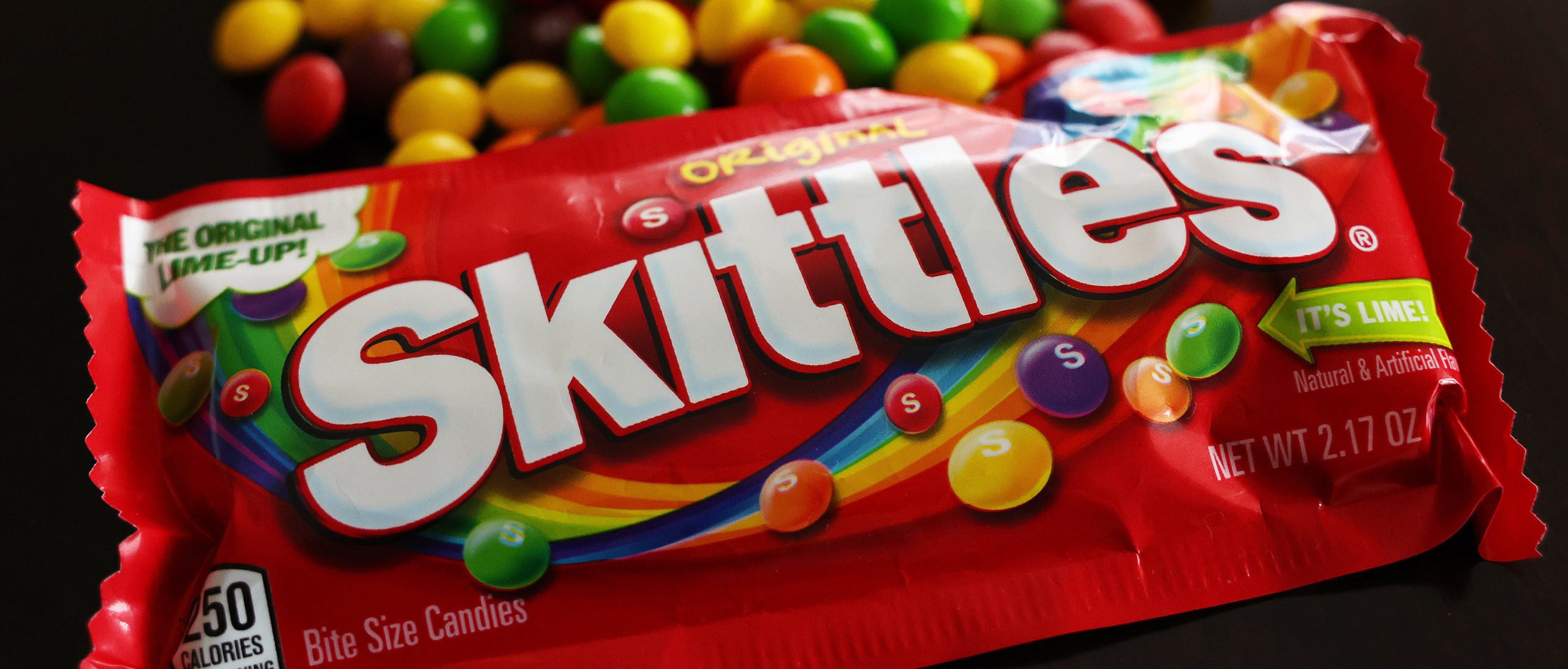 In this photo illustration, packages of Skittles sit on a table on May 30, 2023 in Los Angeles, California. California lawmakers are considering a law banning five chemical food additives over health concerns including the coloring agent used in Skittles candy. (Photo Illustration by Mario Tama/Getty Images)