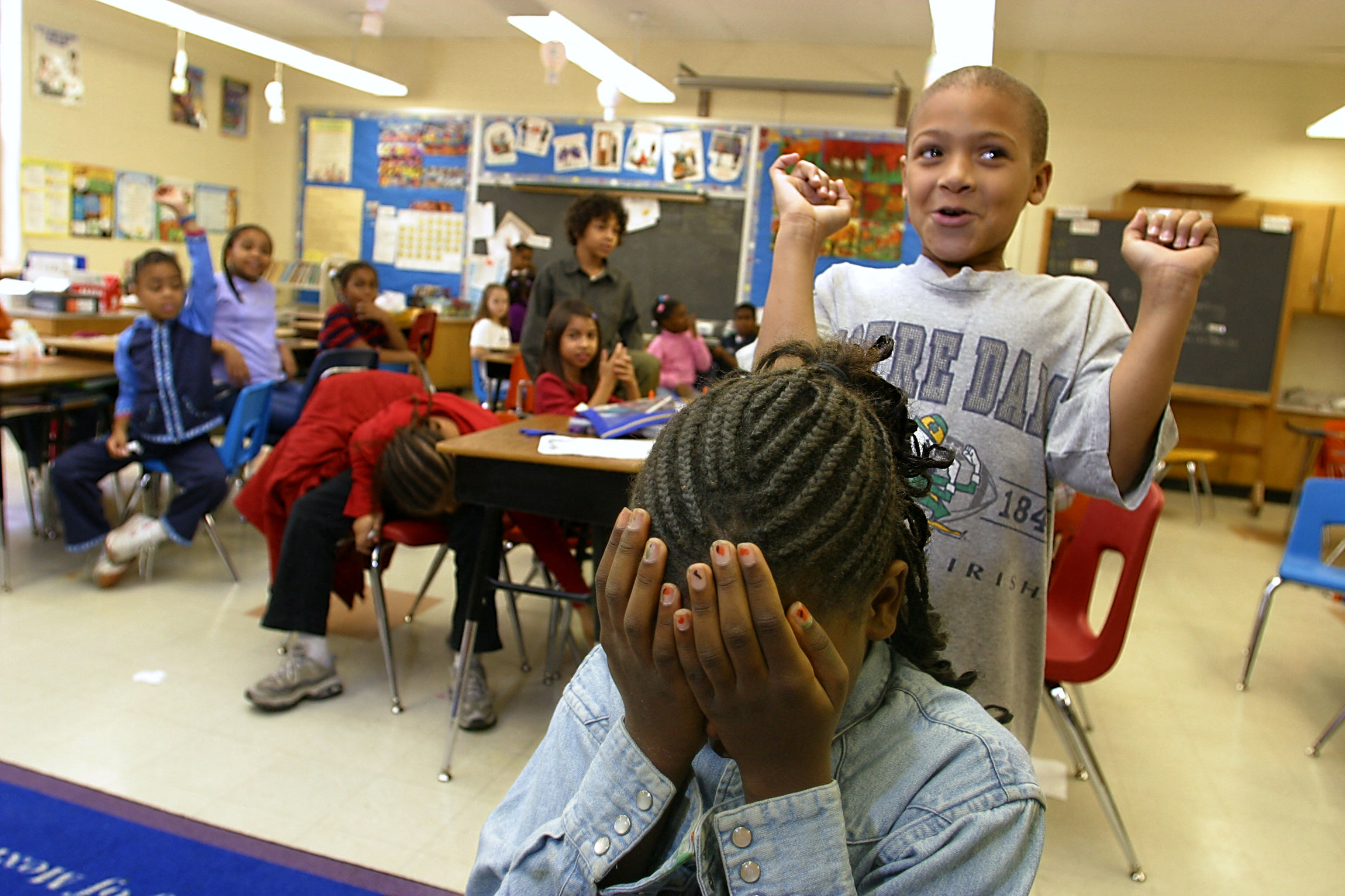 Students in Ms. Beckerman's third grade class play a guessing game in their classroom at Heather Hills Elementary School in Bowie, Maryland 17 October 2002 at recess in place of their normal outdoor activities. Exactly two weeks after the Washington-area snipe gunned down five people in one day, area schools, teachers and students are forced to stay indoors under the constriction of a lockdown, with school doors locked, windows closed and all outdoor activities cancelled. Heather Hills is only 1.5 miles from Benjamin Tasker Middle School where a 13-year old boy was critical injured in a sniper shooting 07 October. AFP PHOTO / Robyn BECK (Photo by ROBYN BECK / AFP) (Photo by ROBYN BECK/AFP via Getty Images)