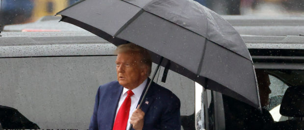 ARLINGTON, VIRGINIA - AUGUST 03: Former U.S. President Donald Trump holds an umbrella as he arrives at Reagan National Airport following an arraignment in a Washington, D.C. court on August 3, 2023 in Arlington, Virginia. Former U.S. President Donald Trump pleaded not guilty to four felony criminal charges during his arraignment this afternoon after being indicted for his alleged efforts to overturn the 2020 election. (Photo by Tasos Katopodis/Getty Images)