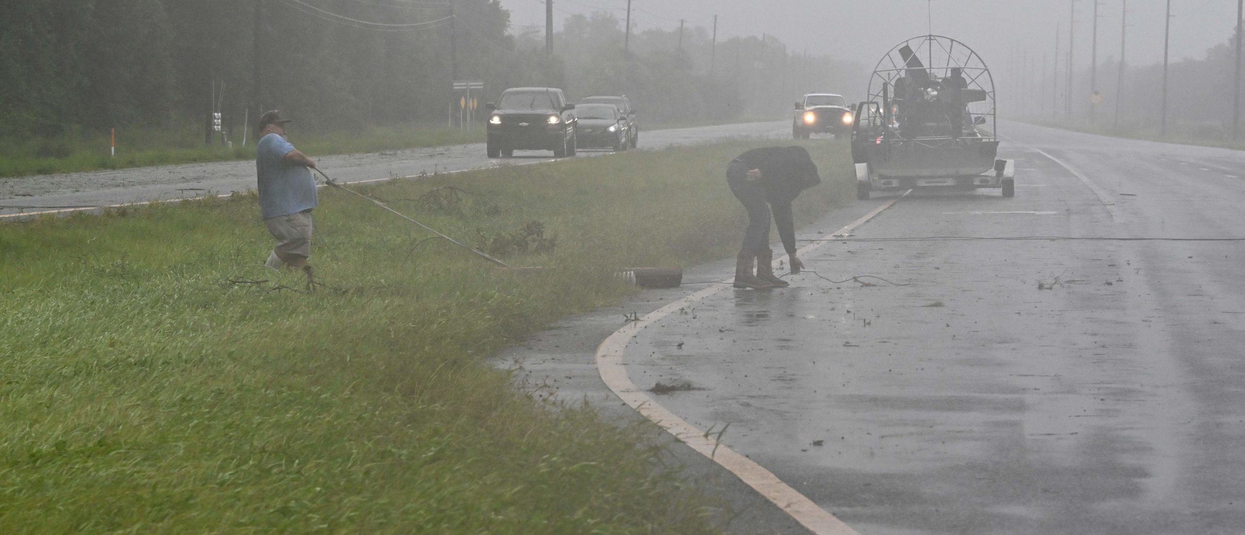 People move debris off a highway in Cross City, Florida, on August 30, 2023, after Hurricane Idalia made landfall. Idalia barreled into the northwest Florida coast as a powerful Category 3 hurricane on Wednesday morning, the US National Hurricane Center said. "Extremely dangerous Category 3 Hurricane #Idalia makes landfall in the Florida Big Bend," it posted on X, formerly known as Twitter, adding that Idalia was causing "catastrophic storm surge and damaging winds." (Photo by Chandan Khanna / AFP) (Photo by CHANDAN KHANNA/AFP via Getty Images)
