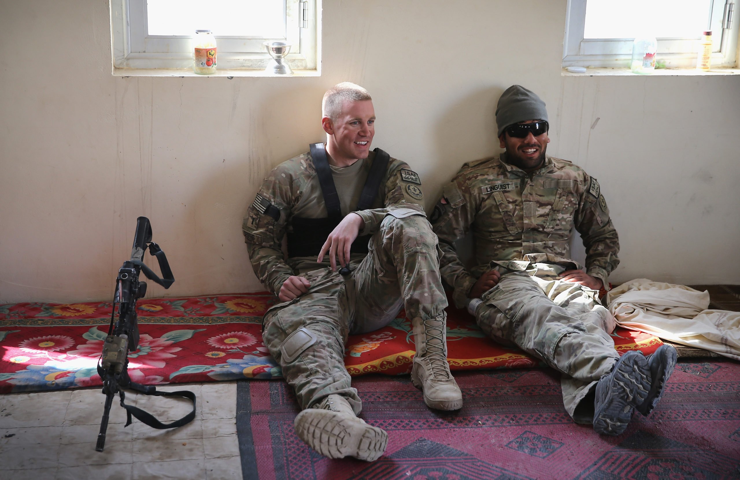 KANDAHAR, AFGHANISTAN - FEBRUARY 26: 1LT Peter Spoehr (L) from Alexandria, Virginia and his Afghan interpreter Wafa with the U.S. Army's 4th squadron 2d Cavalry Regiment wait to meet police at an Afghan National Police (ANP) outpost following a joint patrol of a village February 26, 2014 near Kandahar, Afghanistan. Defense Secretary Chuck Hagel announced he is making preparations for a complete military withdrawal from Afghanistan because Afghanistan President Hamid Karzai continues to refuse to sign the Bilateral Security Agreement. Fourth squadron 2d Cavalry Regiment is responsible for defending Kandahar Airfield against rocket attacks from insurgents. 