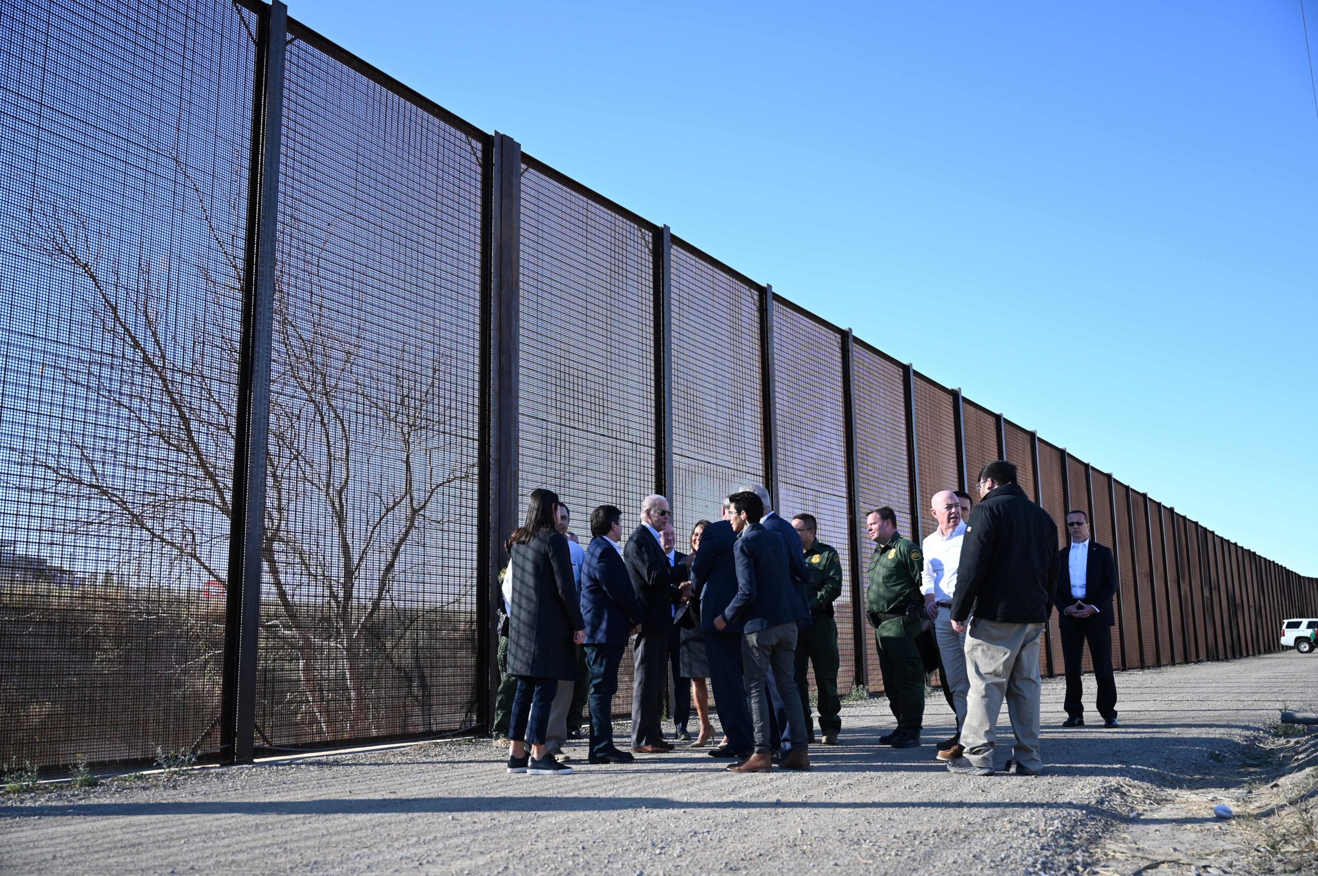 US President Joe Biden speaks with officials in front of the US-Mexico border fence in El Paso, Texas, on January 8, 2023. - Biden went to the US-Mexico border on Sunday for the first time since taking office, visiting an El Paso, Texas entry point at the center of debates over illegal immigration and smuggling. (Photo by Jim WATSON / AFP) (Photo by JIM WATSON/AFP via Getty Images)