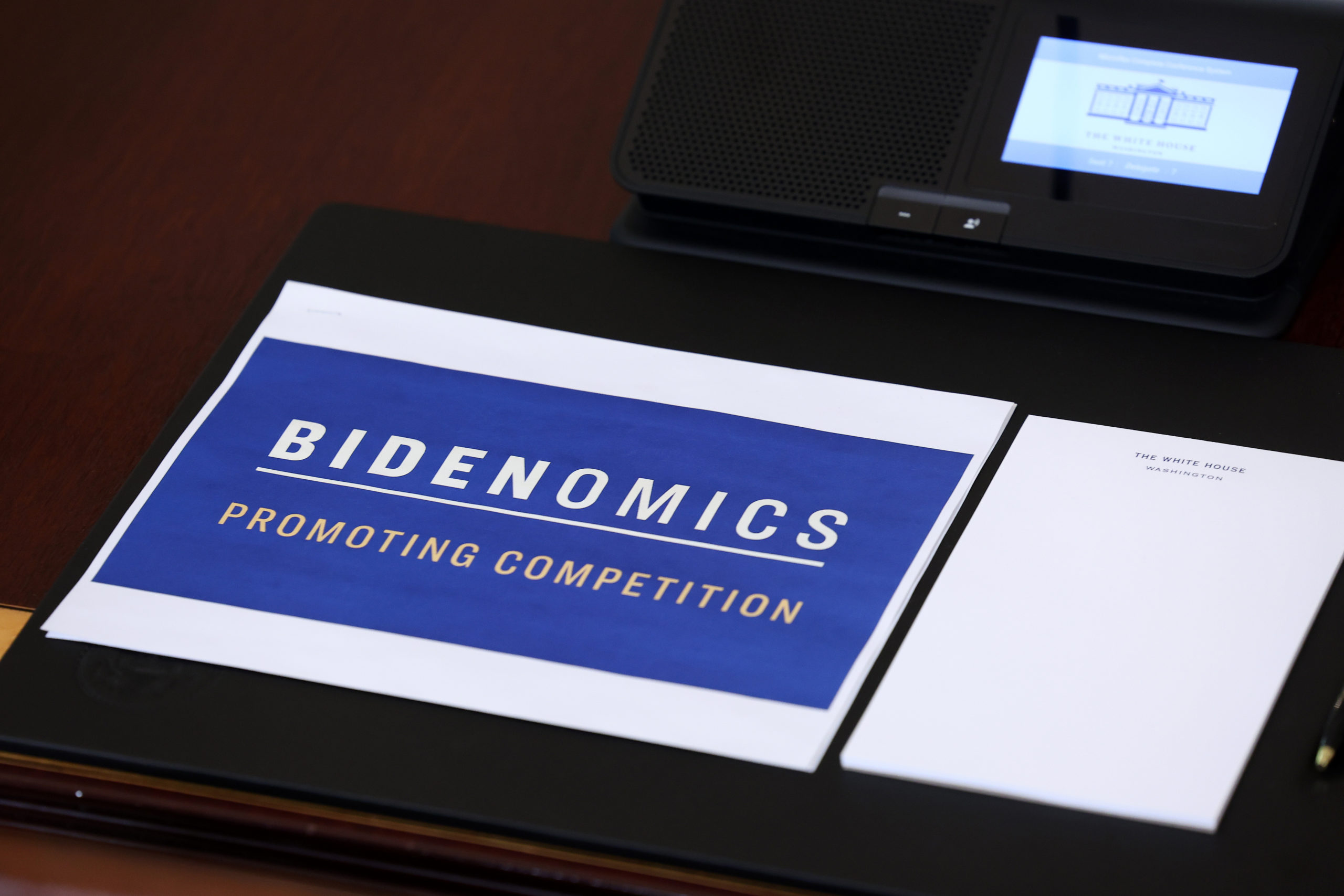 A stack of documents outlining U.S. President Joe Biden's "Bidenomics" economic plan is seen on a table during a meeting of the Competition Council in the State Dinning Room at the White House on July 19, 2023 in Washington, DC. Biden announced new actions aimed at increasing economic competition and strengthening entrepreneurs and small businesses. (Photo by Kevin Dietsch/Getty Images)