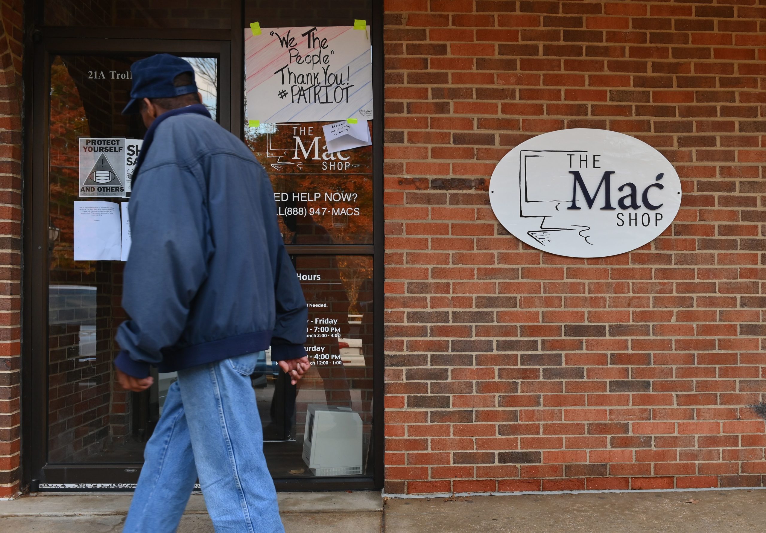 A man walks past "The Mac Shop" in Wilmington, Delaware on October 21, 2020. - The New York Post last week revived allegations against Hunter Biden with a story claiming it had obtained documents from a laptop owned by the former vice president's son which was brought in for repairs to the shop in April 2019 but never picked up. The Post claimed that emails found on the laptop showed that Hunter Biden introduced his father to a Burisma advisor, Vadym Pozharskyi, in 2015 and contradict Joe Biden's claims that he never spoke to his son about his overseas business dealings. The Post said the shop owner handed the laptop over to the FBI and also made a copy of the hard drive and gave it to former New York mayor Rudy Giuliani. (Photo by Angela Weiss / AFP) (Photo by ANGELA WEISS/AFP via Getty Images)
